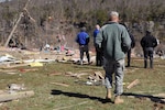 Army Staff Sgt. Joshua Matlock, with the Charlie Battery, 1st Battalion, 623rd Field Artillery (HIMARS), accompanies Kentucky's Lt. Gov. Jerry Abramson as they view the debris that covered the area of East Bernstadt, Ky., March 3, 2012.