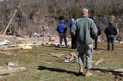 Army Staff Sgt. Joshua Matlock, with the Charlie Battery, 1st Battalion, 623rd Field Artillery (HIMARS), accompanies Kentucky's Lt. Gov. Jerry Abramson as they view the debris that covered the area of East Bernstadt, Ky., March 3, 2012.