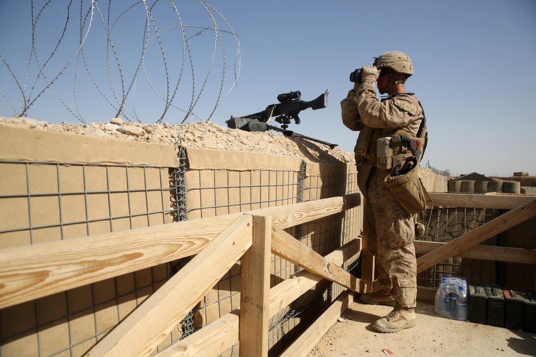 Lance Cpl. Hugo Morales, rifleman, Weapons Company, 1st Battalion, 7th Marine Regiment, scans the surrounding area with binoculars from a security post during a mission in Helmand province, Afghanistan, June 13, 2014. Morales, a native of El Paso, Texas, along with a platoon of infantrymen, provided security at Patrol Base Ouellette, an Afghan National Army controlled-base, during the Afghanistan presidential runoff elections. While International Security Assistance Force stood ready to support as needed, the elections were entirely Afghan led and Afghan conducted.
