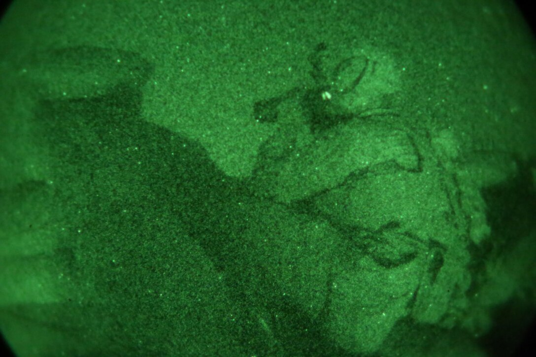 Corporal Domingo Espinal, machine gunner, Weapons Company, 1st Battalion, 7th Marine Regiment, scans the surrounding area with thermal binoculars from a security post during a mission in Helmand province, Afghanistan, June 13, 2014. Espinal, a native of Athens, Ga., along with a platoon of infantrymen, provided security at Patrol Base Ouellette, an Afghan National Army controlled-base, during the Afghanistan presidential runoff elections. While International Security Assistance Force stood ready to support as needed, the elections were entirely Afghan led and Afghan conducted.