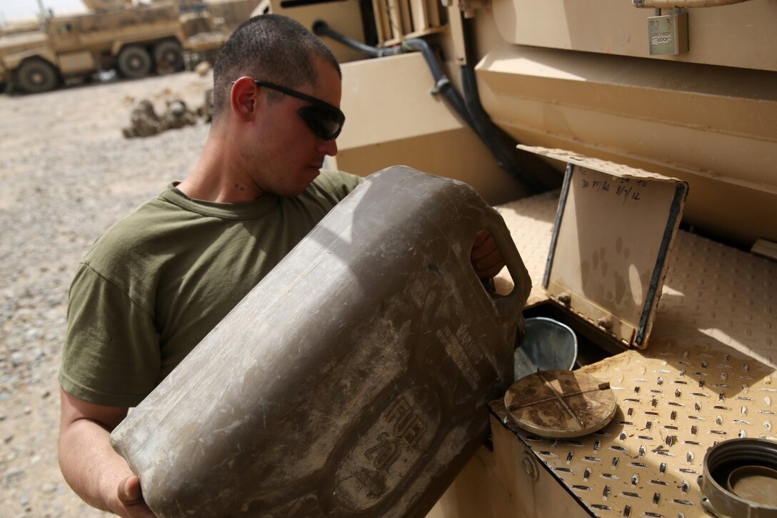 Lance Cpl. Hugo Morales, rifleman, Weapons Company, 1st Battalion, 7th Marine Regiment, fills a fuel tank of a Mine-Resistant Ambush Protected vehicle during a mission in Helmand province, Afghanistan, June 13, 2014. Morales, a native of El Paso, Texas, along with a platoon of infantrymen, provided security at Patrol Base Ouellette, an Afghan National Army controlled-base, during the Afghanistan presidential runoff elections. While International Security Assistance Force stood ready to support as needed, the elections were entirely Afghan led and Afghan conducted.