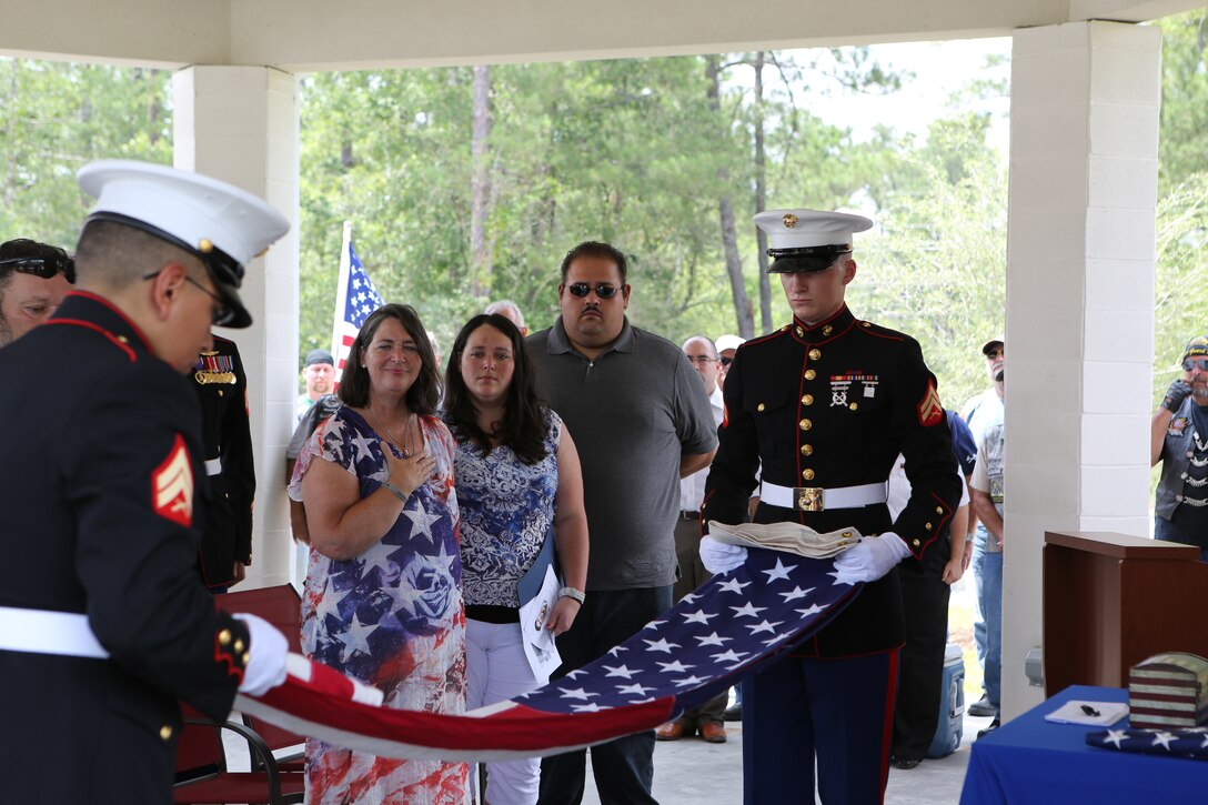 Mrs. Gina Guillory looks on as Marines from Headquarters Battalion, Marine Forces Reserve, fold a U.S. flag honoring her son, Sgt. Michael Guillory, who was killed in Afghanistan 18 months ago. The funeral service took place at the newly opened Southeast Louisiana Veterans Cemetery in Slidell, Louisiana, June 21, 2014. Guillory received full military honors and was the first to be laid to rest at the cemetery. 