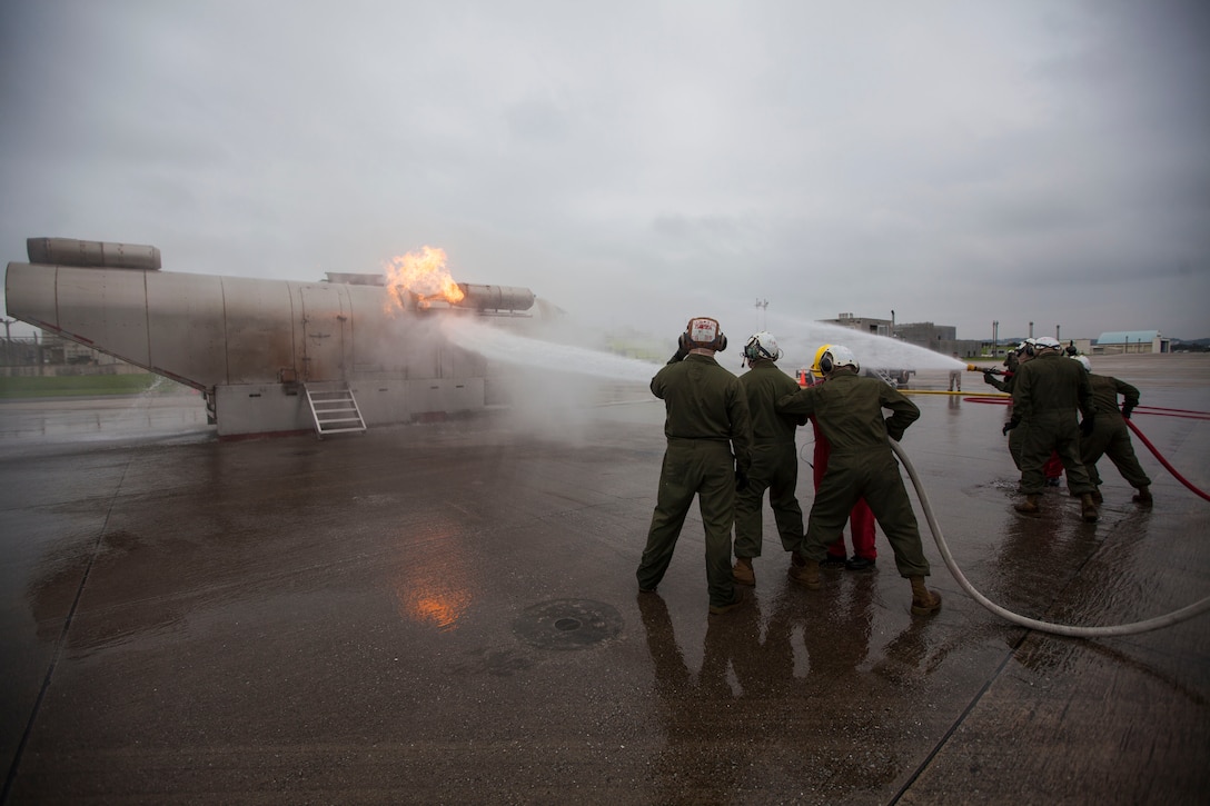 Marines with Marine Medium Tiltrotor Squadron 262 (Reinforced), 31st Marine Expeditionary Unit, spray water on the Mobile Aircraft Firefighting Training Device during a crash fire rescue scenario at the base fire station, June 19, 2014. The week-long course instructed Marines on advancing and sweeping techniques with the hoses on a burning mock aircraft. The Marines are not from firefighting billets but are taught to be first-responders to potential aircraft accidents when the unit is embarked aboard Navy ships with the MEU. The 31st MEU is the force of choice for the Asia-Pacific and is the only continuously forward-deployed MEU.