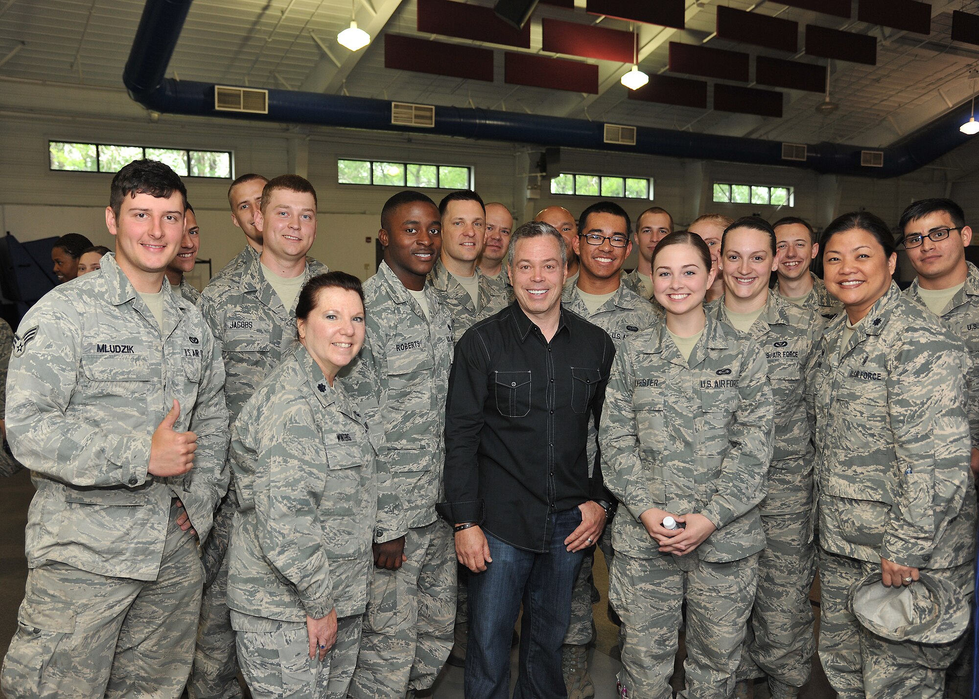 Members of the 319th Air Base Wing gather for a group picture with comedian Bernie McGrenahan June 20, 2014, at Liberty Square on Grand Forks Air Forks Base, N.D. McGrenahan told his message of high-risk drinking, DUI reduction and suicide prevention through a 30-minute stand-up comedy show. (U.S. Air Force photo/Senior Airman Xavier Navarro)