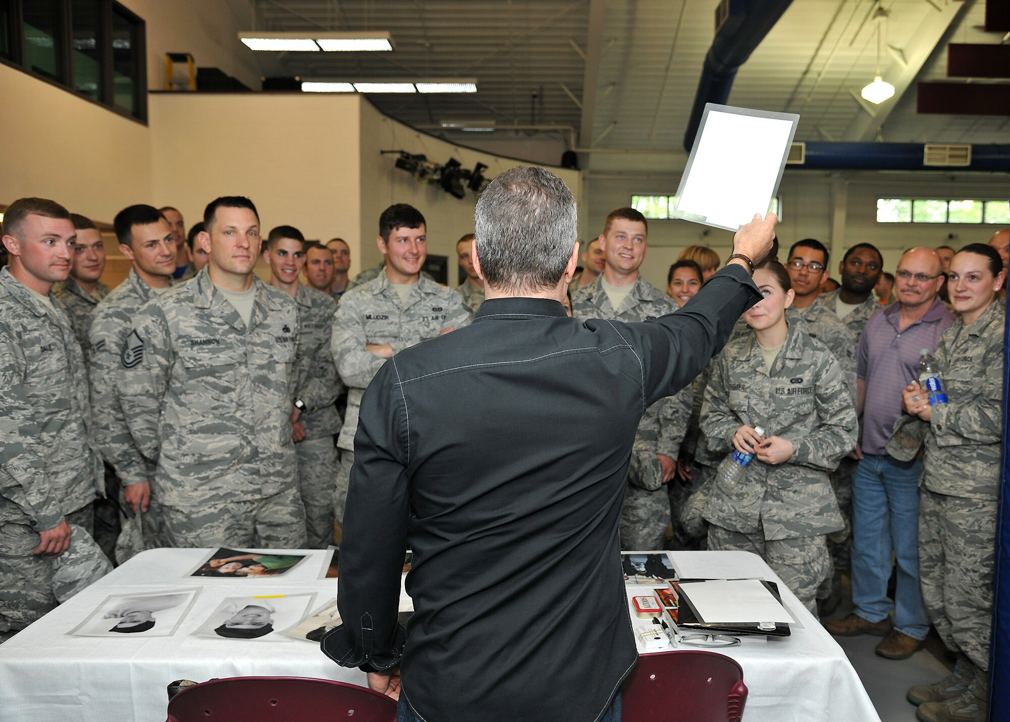 Stand-up comedian Bernie McGrenahan shows a picture of his younger brother to Airmen June 20, 2014, at Liberty Square on Grand Forks Air Force Base, N.D. McGrenahan tours military bases to inspire troops to stay focused and resilient, giving two performances on Grand Forks AFB. (U.S. Air Force photo/Senior Airman Xavier Navarro)