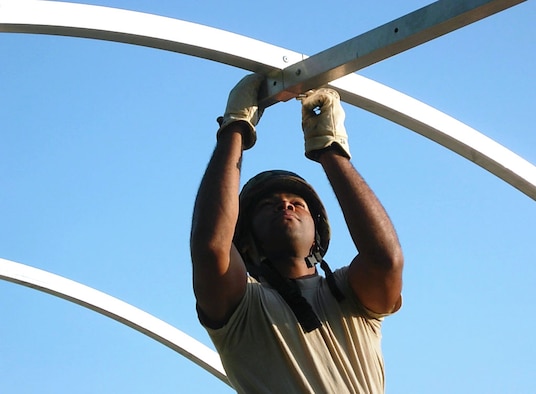 Senior Airman Marco Bowen, a food service personnel worker with the 137th Service Sustainment Flight, helps assemble a small shelter system frame during the Force Support Silver Flag exercise, a weeklong total force exercise June 6 – 14, 2014, at Dobbins Air Reserve Base, Georgia.  Bowen earned the Top Performer Award during the exercise. (U.S. Air Force photo by Lt. Col. LeeAnn Tumblson)