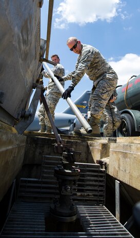 Col. Jeffrey DeVore, Joint Base Charleston commander, and Chief Master Sgt. Mark Bronson, 628th Air Base Wing command chief, prep a hose to drain wastewater from a hydrant system on the flightline, June 18, 2014, at Joint Base Charleston, S.C.  Each month, DeVore and his staff visit a different 628th ABW agency and receive hands-on tutorials on specific jobs. As fuels hydrant operators, Devore, Bronson and Master Chief Petty Officer Joseph Gardner, Naval Support Activity command master chief, learned how to drain wastewater on the flight line, refuel a Boeing C-17 Globemaster III, and test samples of aircraft fuel. (U.S. Air Force photo/Tech. Sgt. Rasheen Douglas)