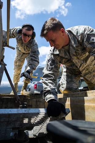 Airman First Class Damien Johnson, 628th Logistics Readiness Squadron fuels hydrant operator , watches as Chief Master Sgt. Mark Bronson, 628th Air Base Wing command chief, preps a hose to drain wastewater from a hydrant system on the flightline, June 18, 2014, at Joint Base Charleston, S.C.  Each month, Col. Jeffrey DeVore, Joint Base Charleston commander, and his staff, visit a different 628th ABW agency and receive hands-on tutorials on specific jobs. Working with the 628th LRS, Devore, Bronson and Master Chief Petty Officer Joseph Gardner, Naval Support Activity command master chief, learned how to drain wastewater on the flight line, refuel a Boeing C-17 Globemaster III, and test samples of aircraft fuel. (U.S. Air Force photo/Tech. Sgt. Rasheen Douglas)