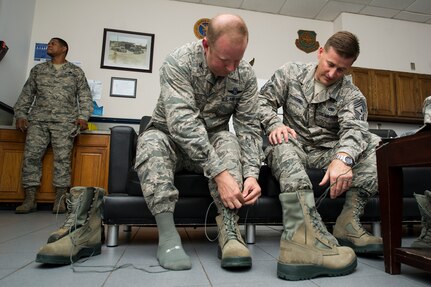 Col. Jeffrey DeVore, Joint Base Charleston commander, and Chief Master Sgt. Mark Bronson, 628th Air Base Wing command chief, lace up their steel-toe boots before going to work with the 628th Logistics Readiness Squadron Petroleum, Oil and Lubricants section June 18, 2014, at Joint Base Charleston , S.C.  Each month, DeVore and his staff visit a different 628th unit and receive hands-on tutorials on specific job. As fuels hydrant operators, Devore, Bronson, and Master Chief Petty Officer Joseph Gardner, Naval Support Activity command master chief, learned how to drain wastewater on the flight line, refuel a Boeing C-17 Globemaster III and test samples of aircraft fuel. (U.S. Air Force photo/Tech. Sgt. Rasheen Douglas)