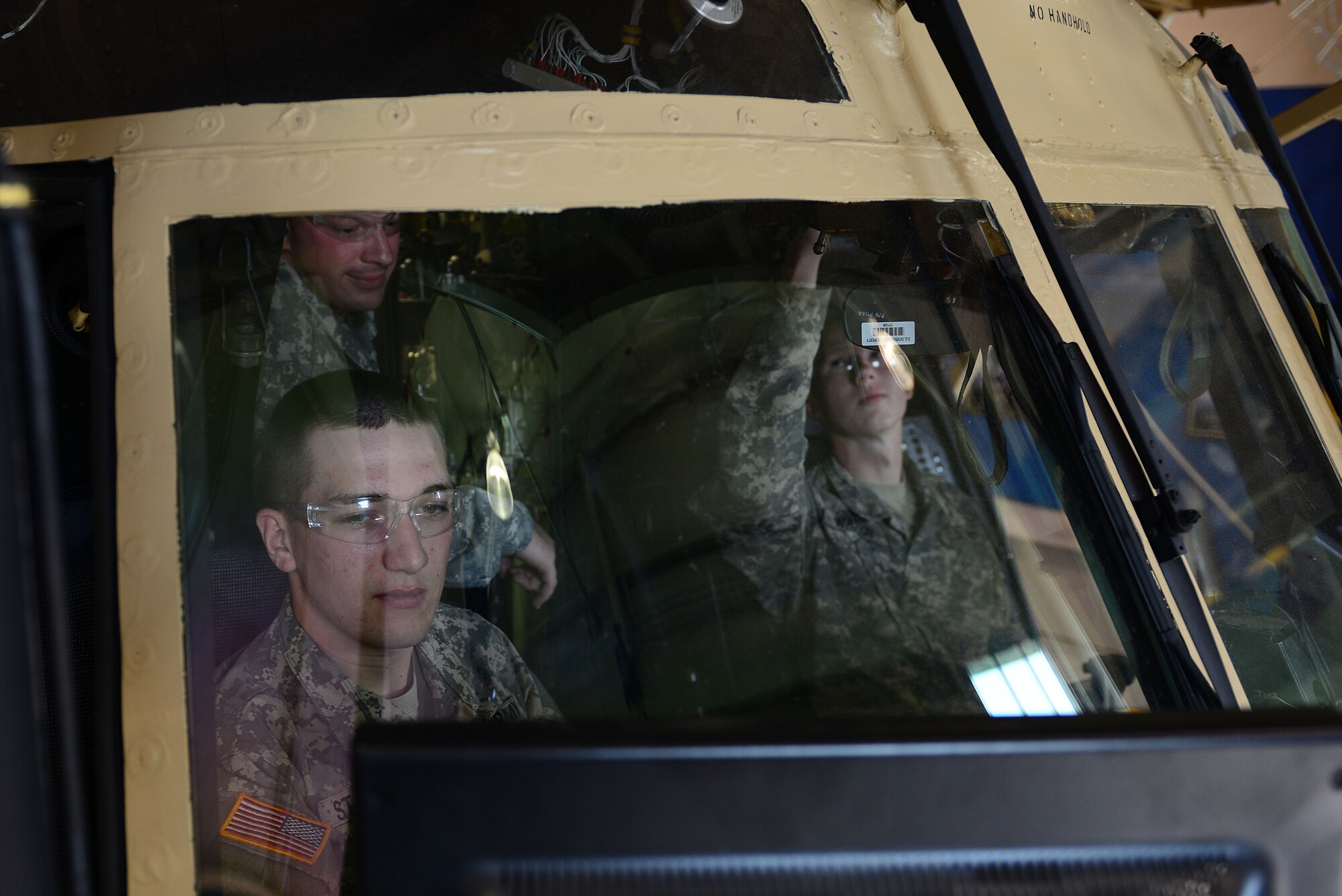 U.S. Army Staff Sgt. Joseph Batts, A Company, 2nd Battalion, 210th Aviation Regiment medium repair supervisor course instructor, instructs Advanced Individual Training students while they work on the common avionics architecture system in a Chinook CH-47 training aircraft at Fort Eustis, Va., June 17, 2014. The newer model aircraft trainers look almost identical to active aircraft, but have different components added for training purposes, such as windows on sections that are typically covered and monitors mounted on the sides of the aircraft. These functions allow students to access manuals, and allow instructors to direct students through various tasks. (U.S. Air Force photo by Airman 1st Class Kimberly Nagle/Released) 