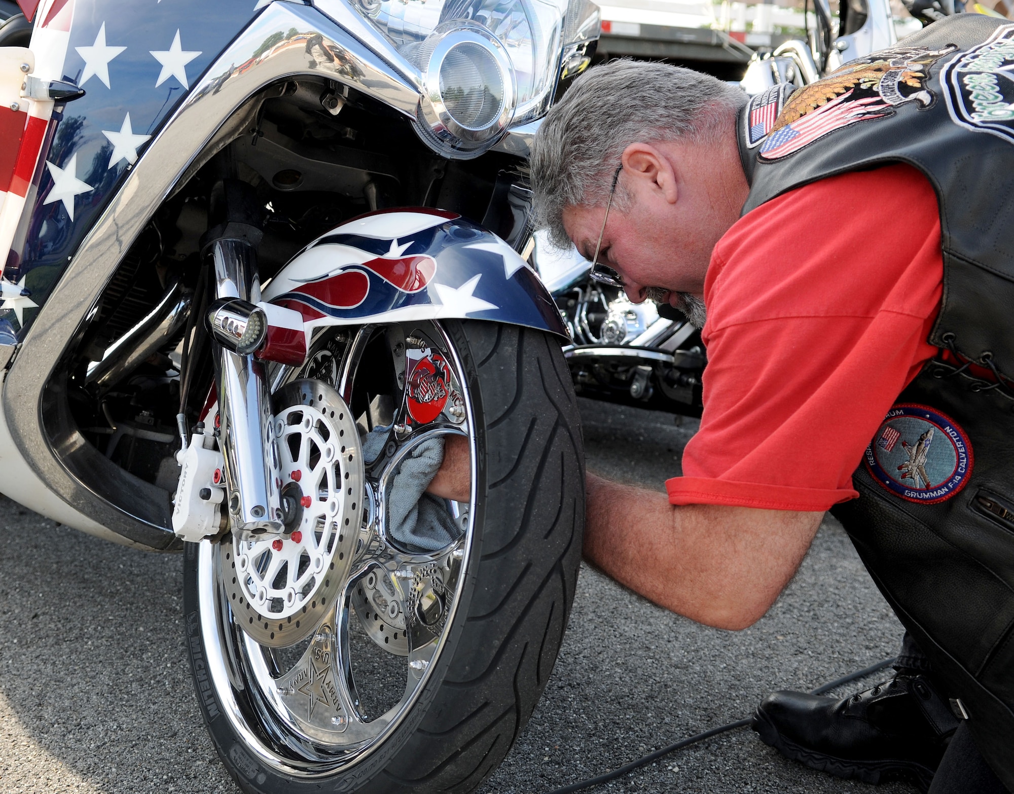 Harry Waddle, 11th Wing Safety Office, wing weapons safety manager, cleans his motorcycle before an off-base ride. Team Andrews members gathered for the 4th Annual Motorcycle Safety Day on Joint Base Andrews, Md., June 20, 2014. (U.S. Air Force photo/Airman 1st Class Ryan J. Sonnier)