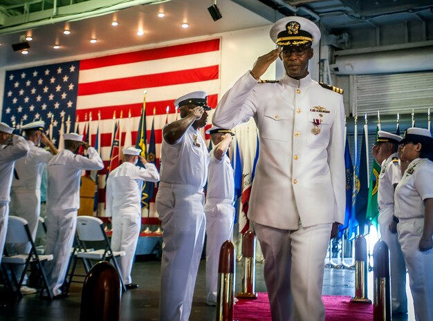 Commander Marquis Patton salutes the side boys as he is piped ashore during his retirement ceremony June 20, 2014, onboard USS Yorktown (CV 10) in Mount Pleasant, SC. Patton served 35 years in the U.S. Navy, beginning his career in 1979 as an enlisted seaman and being selected to chief petty officer before being commissioned and making his way through the officer ranks before retiring as a commander. (U.S. Air Force Photo/Senior Airman Tom Brading) 

