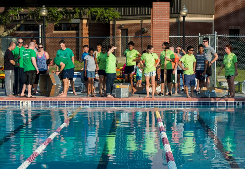 Moody members make the final touches on their team-made boats during the 2014 Build a Boat competition at Moody Air Force Base, Ga., June 19, 2014. Once the race started, the competitors had to get inside their boat and race across the base pool. (U.S. Air Force photo by Senior Airman Douglas Ellis/Released)
