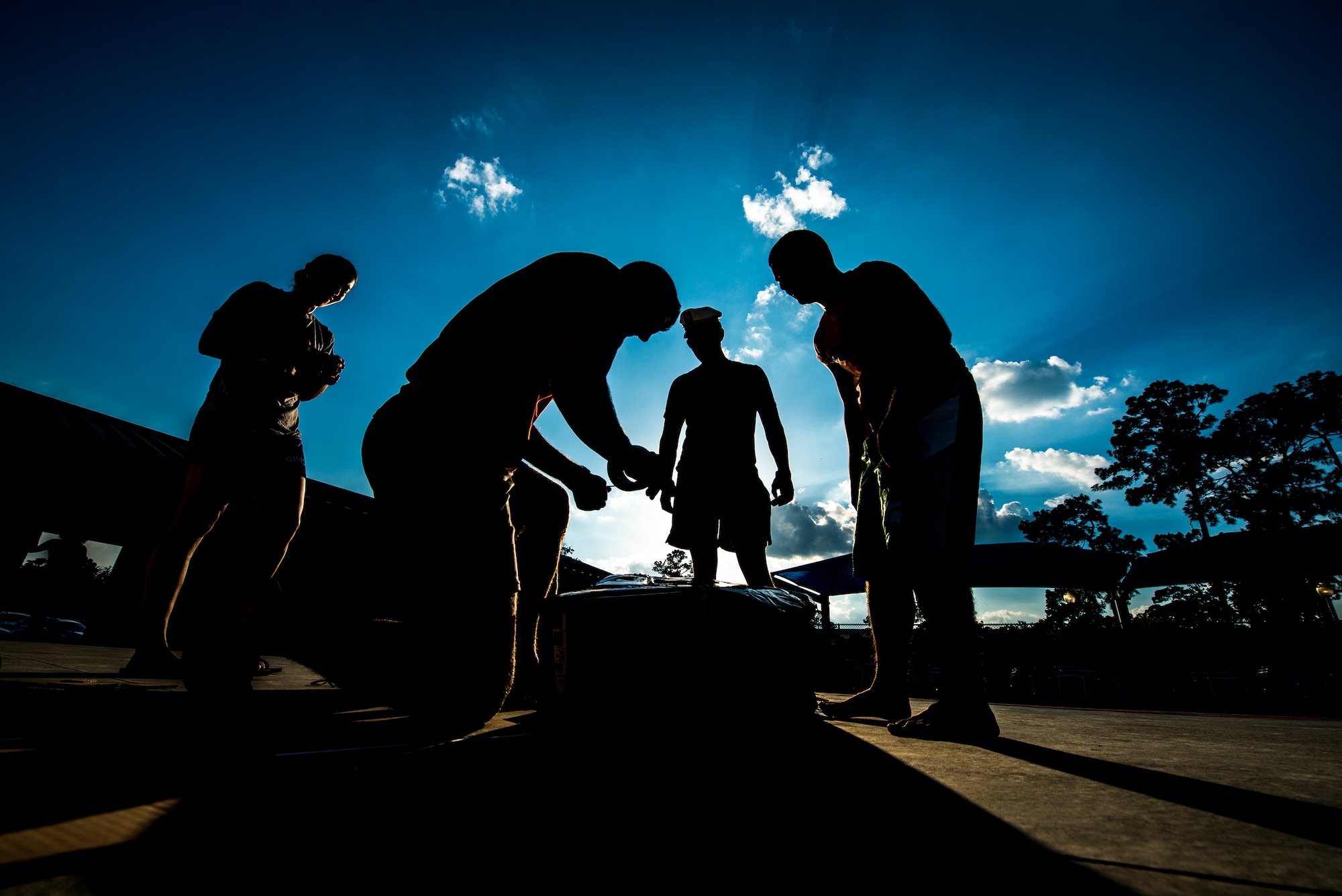 Members of the 23d Force Support Squadron create a boat that will be raced across the base pool during the 2014 Build a Boat competition at Moody Air Force Base, Ga., June 19, 2014. All participants were given 45 minutes to create a boat using cardboard, duct tape and box cutters. (U.S. Air Force photo by Senior Airman Douglas Ellis/Released)
