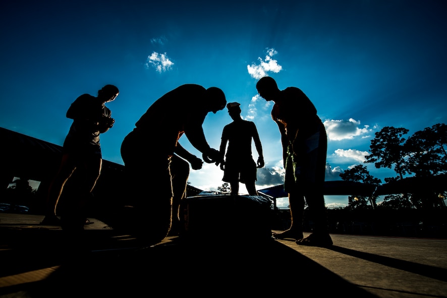 Members of the 23d Force Support Squadron create a boat that will be raced across the base pool during the 2014 Build a Boat competition at Moody Air Force Base, Ga., June 19, 2014. All participants were given 45 minutes to create a boat using cardboard, duct tape and box cutters. (U.S. Air Force photo by Senior Airman Douglas Ellis/Released)
