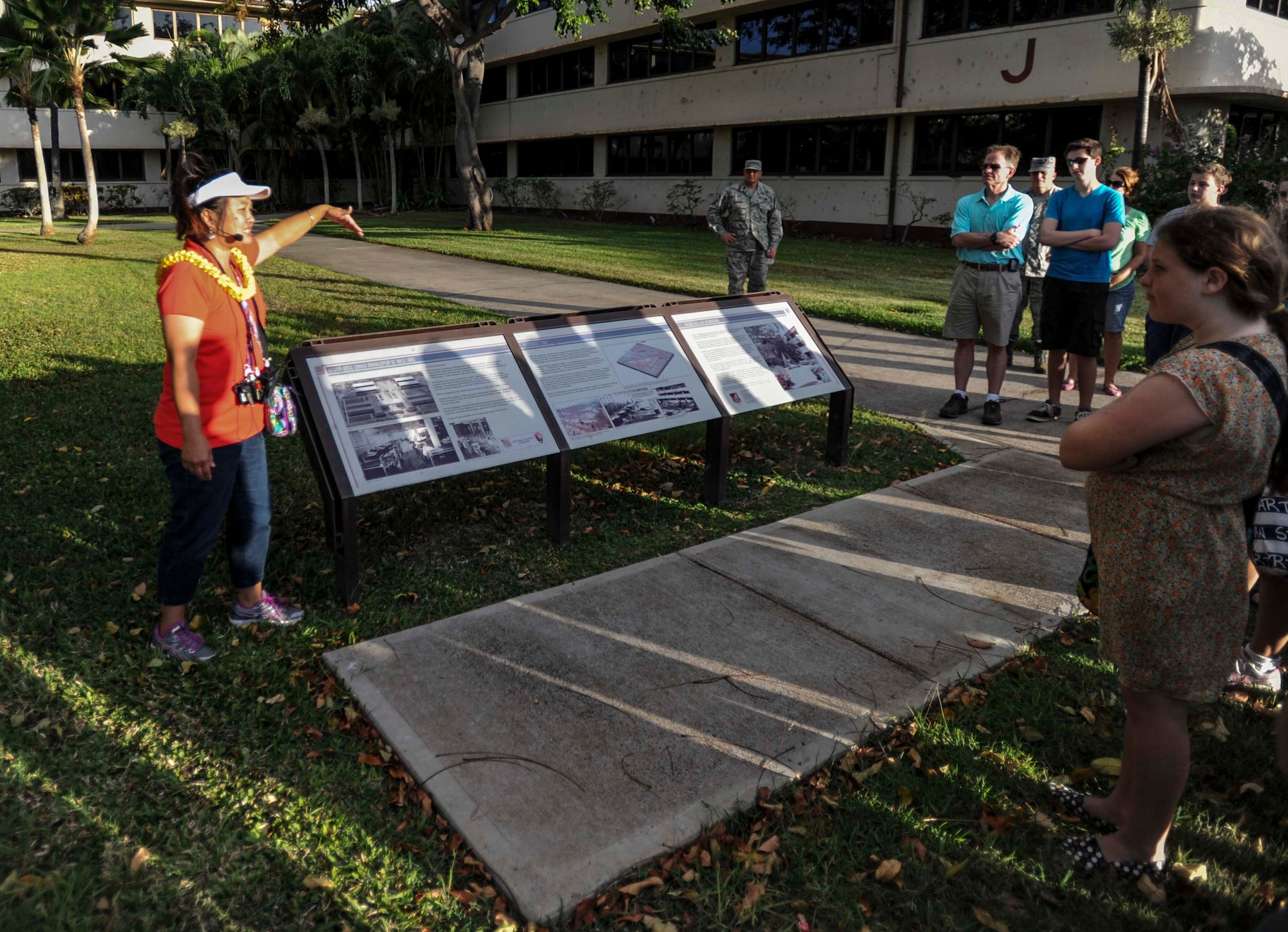 Jessie Higa, Hickam History Club president, details how the Dec. 7, 1941, attack on Pearl Harbor and Hickam Field damaged Hickam Field Barracks to a group of local community members and honorary commanders during a walking tour of the historical sites on Hickam Field June 18, 2014. Hickam Field Barracks has since become the Pacific Air Forces Headquarters building. (U.S. Air Force photo/Tech. Sgt. Terri Paden)