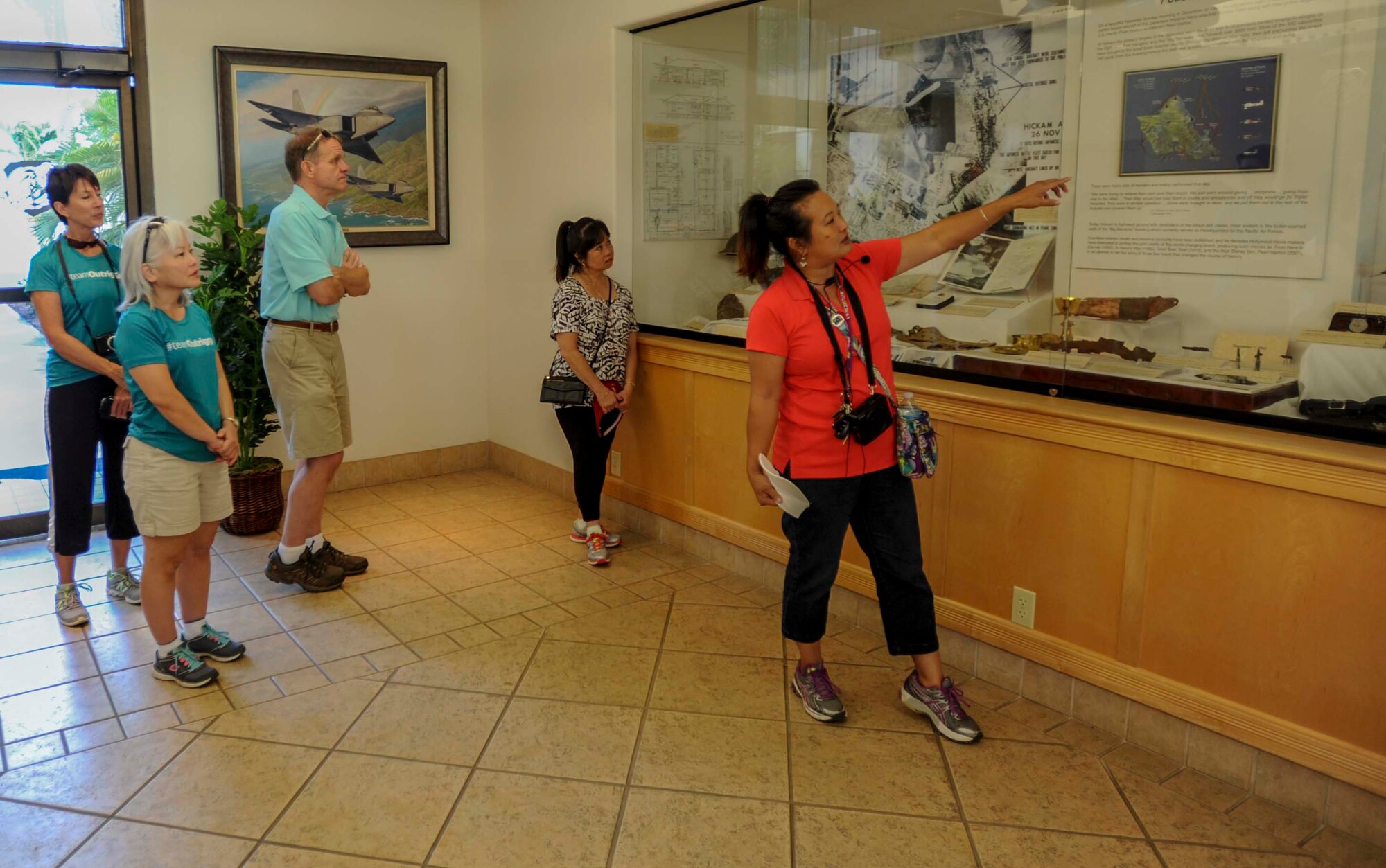 Jessie Higa, Hickam History Club president, explains historical memorabilia on display in the 15th Wing headquarters building to a group of local community members and honorary commanders during a walking tour of the historical sites on Hickam Field June 18, 2014. (U.S. Air Force photo/Tech. Sgt. Terri Paden)