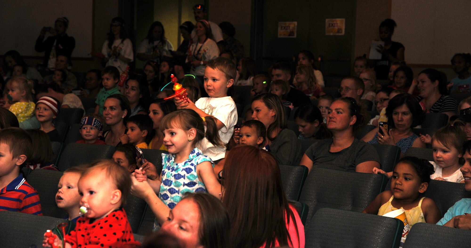 Children and their families dance and sing along with Sesame Street characters during the Sesame Street/USO Experience for Military Families June 20 at the Malmstrom Air Force Base auditorium. Children got to see some of their favorite Sesame Street characters such as Elmo and Cookie Monster, but also got the opportunity to see Katie, who is a military child herself. (U.S. Air Force photo/Airman 1st Class Joshua Smoot)