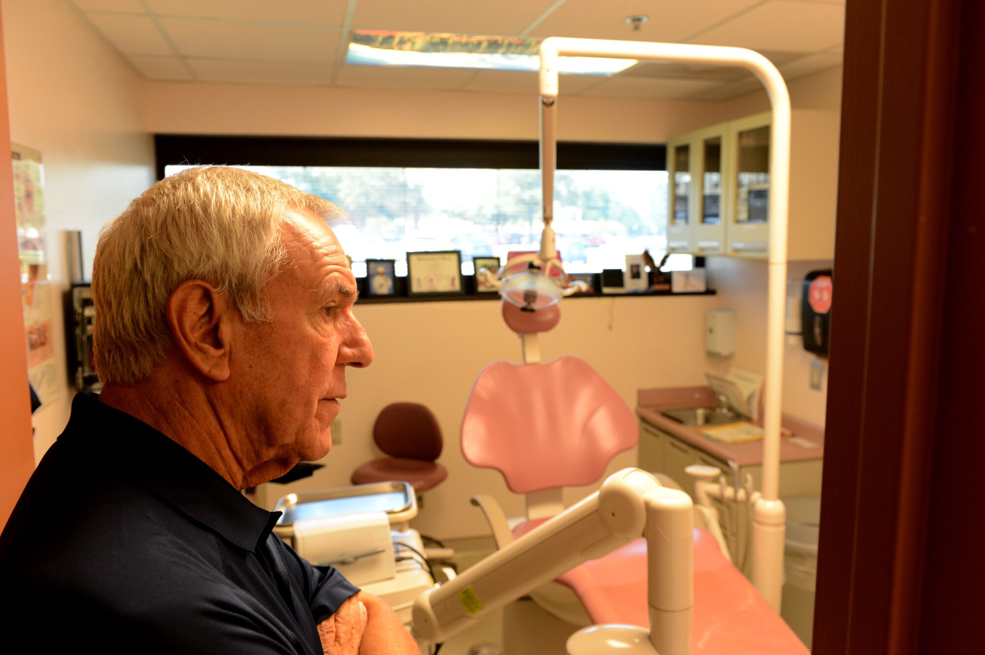 Former U.S. Air Force Capt. John Shinto looks into a room at the 20th Dental Squadron at Shaw Air Force Base, S.C., June 16, 2014. Shinto, a former Air Force dentist, visited the 20th DS during his tour of the base, speaking with the staff and answering questions about dentistry. (U.S. Air Force photo by Airman 1st Class Jensen Stidham/Released)