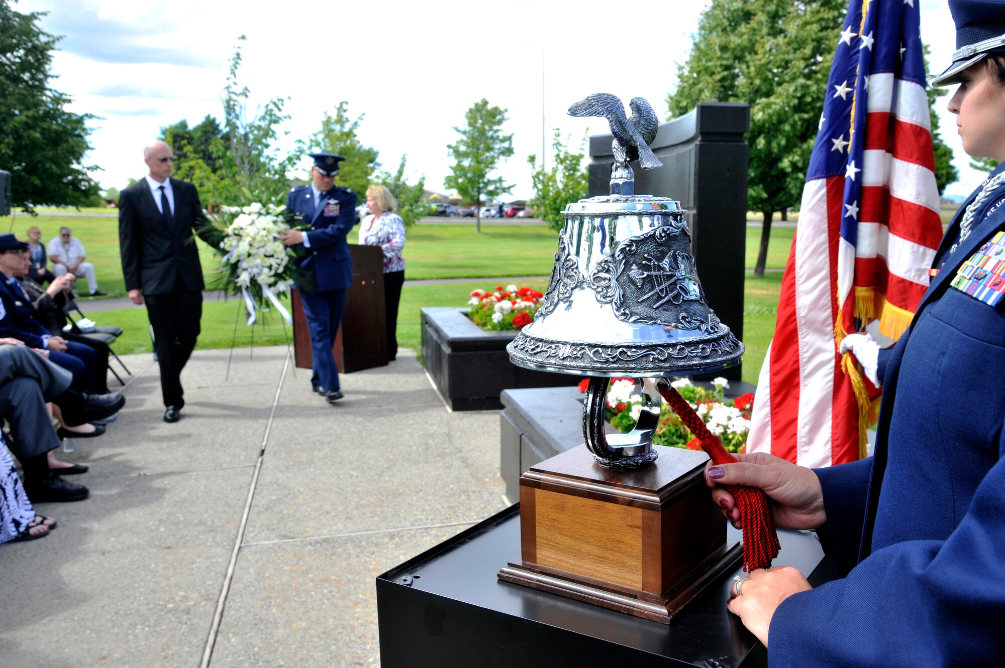 Col. Brian Newberry and retired Staff Sgt. Andrew Brown carry a memorial wreath during a ceremony in remembrance of the fatal hospital shooting 20 years ago at Fairchild Air Force Base, Wash., June 20, 2014. A ceremonial bell was rang as each victim's name was called and family members and friends placed white roses on the memorial statue. Brown was responsible for shooting the gunman, saving countless lives. Newberry is the 92nd Air Refueling Wing commander. (U.S. Air Force photo by Senior Airman Mary O'Dell/Released)
