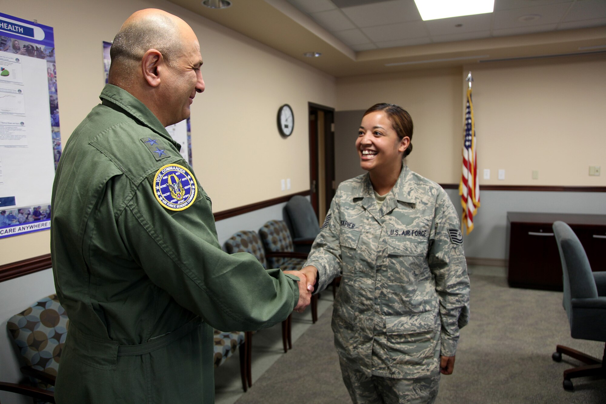 TRAVIS AIR FORCE BASE, Calif. --Maj. Gen. Richard S. "Beef" Haddad, Vice Commander of the Air Force Reserve Command, presents a coin to Tech. Sgt. Nikole D. Napier, 349th Aerospace Medicine Squadron, in recognition for her work on the 349th Air Mobility Wing's innovative fitness clinic at David Grant USAF Medical Center, Travis Air Force Base, Calif., June 21, 2014. The clinic streamlines the process for determining medical profiles; ensuring fitness testing is not delayed by administrative requirements. The general visited facilities and met with Airman to see air mobility innovations helping Travis AFB personnel deliver America's hope and might around the globe. (U.S. Air Force photo/Lt. Col. Robert Couse-Baker)