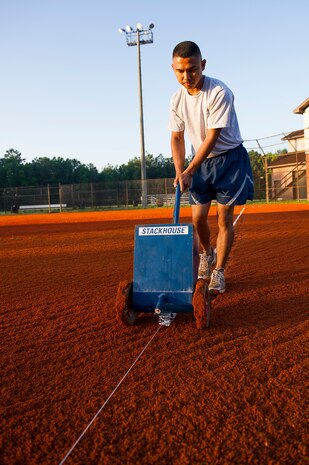 Staff Sgt. Lakan Ello, 628th Force Support Squadron fitness specialist, uses a chalk dispenser to put down a boundary line June 18, 2014, at Joint Base Charleston, S.C. New chalk lines are put down every game day to keep the field maintained for the players. (U.S. Air Force photo/Senior Airman George Goslin)