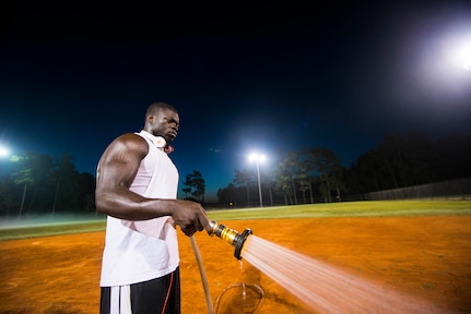 Staff Sgt. David Johnson, 628th Force Support Squadron sports program director, waters an infield, June 18, 2014, at Joint Base Charleston, S.C. The fields are watered to soften them up to give players more traction and prevent injury. (U.S. Air Force photo/Senior Airman George Goslin)