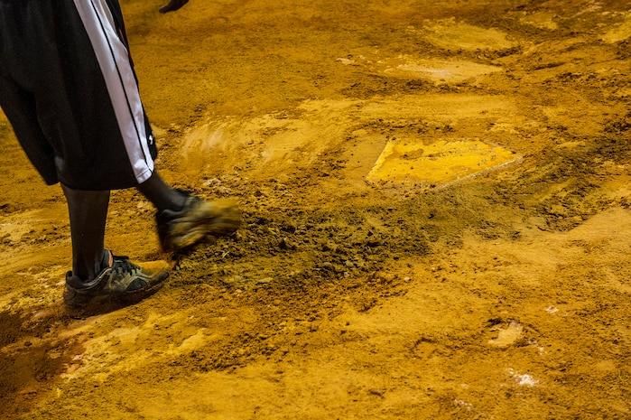Staff Sgt. David Johnson, 628th Force Support Squadron sports program director, fixes holes and divots around home plate, June 18, 2014, at Joint Base Charleston, S.C. The fields are watered to soften them up to give players more traction and prevent injury. (U.S. Air Force photo/Senior Airman George Goslin)