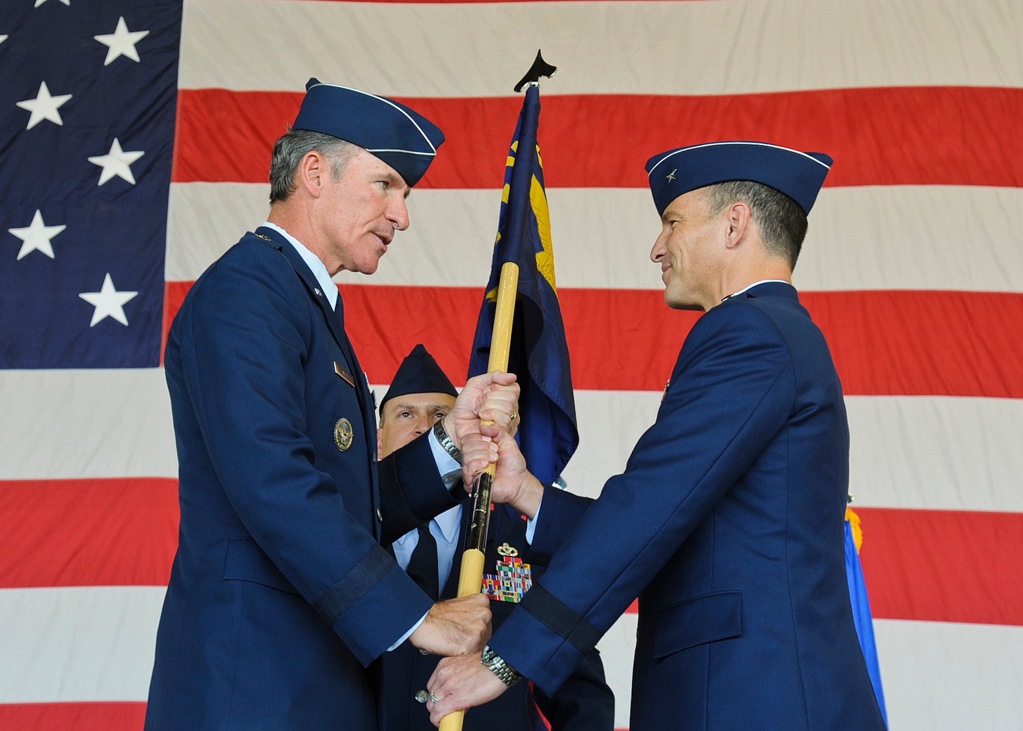 Maj. Gen. Michael Keltz, director of intelligence, operations and nuclear integration at Air Education and Training Command headquarters, passes the 56th Fighter Wing guidon to Brig. Gen. Scott Pleus, incoming 56th Fighter Wing commander, during a change-of-command ceremony at Luke Air Force Base on June 20. Pleus, an F-16 command pilot with more than 2,300 flying hours including combat time in operations Desert Fox and Southern Watch, comes to Luke from the Pentagon, where he served as executive officer to the chief of staff of the Air Force. (U.S. Air Force photo/Staff Sgt. Darlene Setlmann)