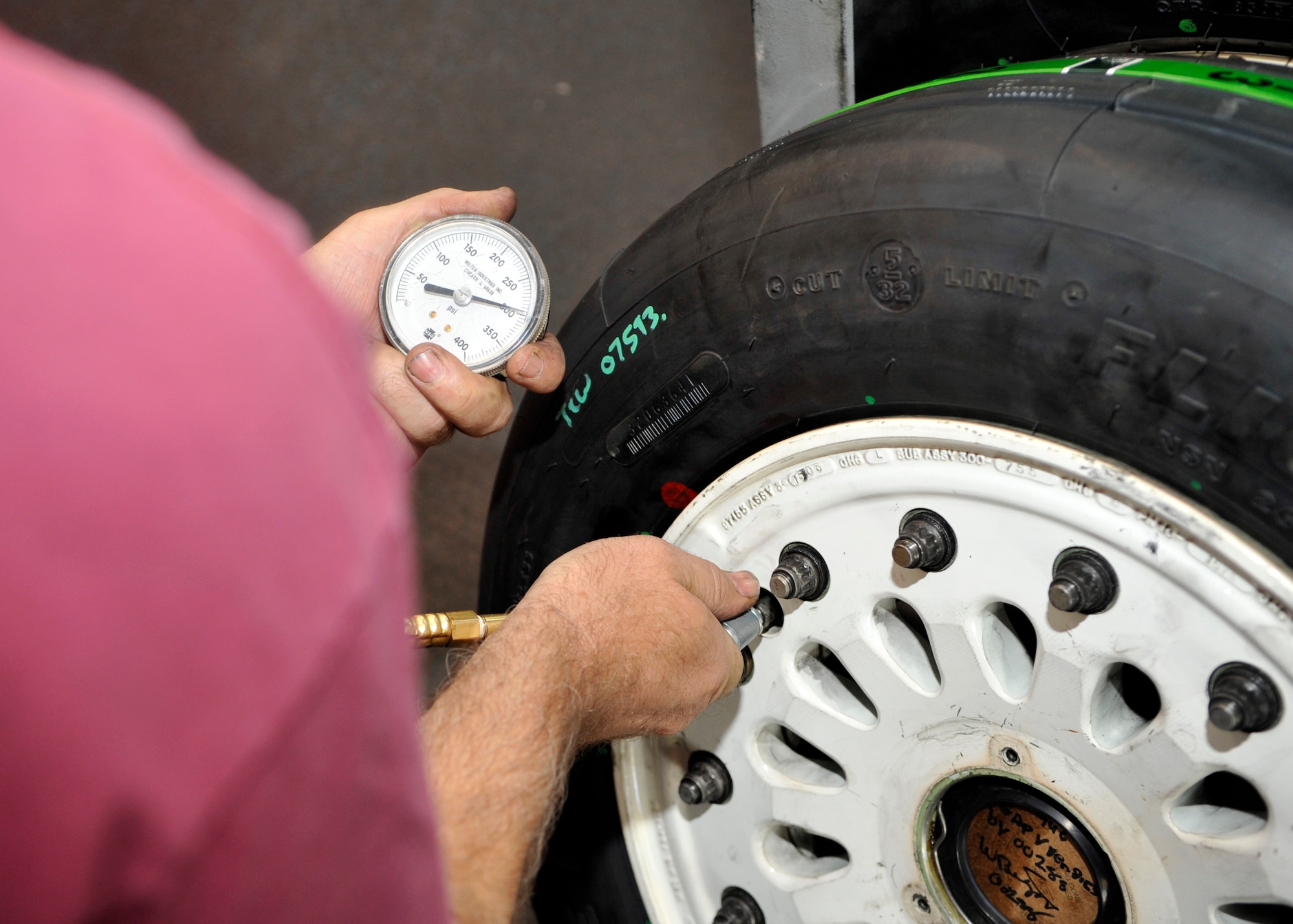 William Biggs, 56th EMS Wheel and Tire Shop tire mounter, checks tire pressure. (U.S. Air Force photo/Senior Airman Marcy Copeland)