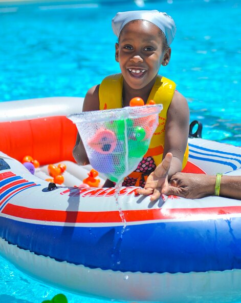 Anaya Walker, 6, daughter of retired Tech. Sgt. Maurie Walker, collects toy ducks at the event. Children were required to gather as many toy ducks as they could to win a prize. (U.S. Air Force photo/Airman 1st Class Cory Gossett)
