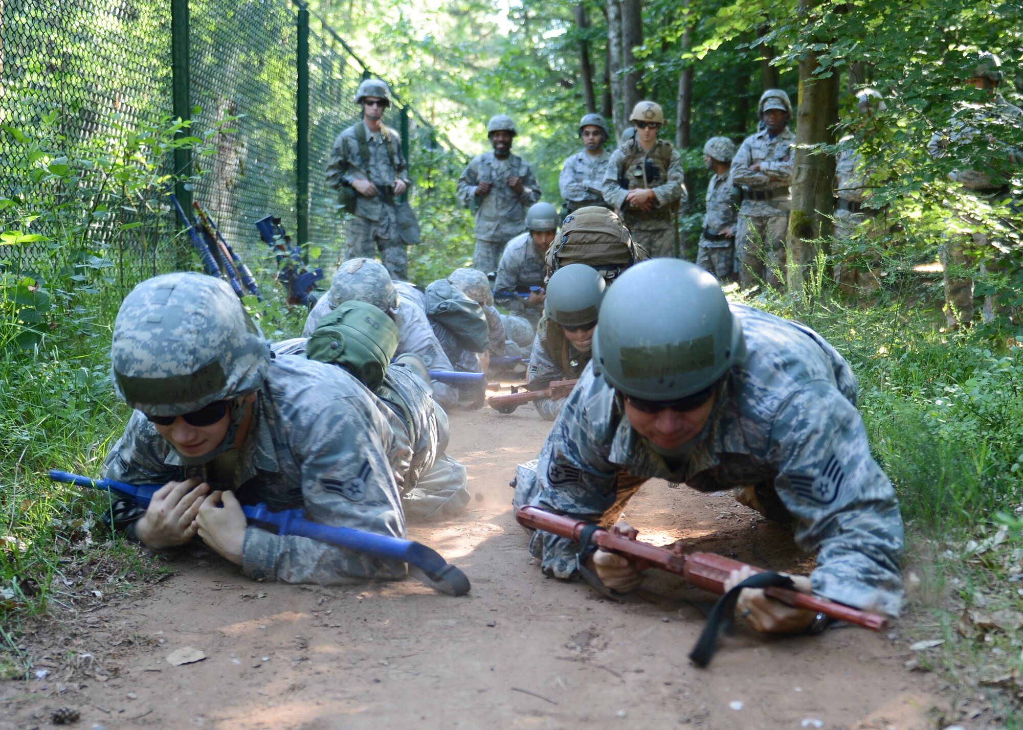 Airmen high-crawl through the woods during Prime BEEF (Base Engineer Emergency Forces) Day on Ramstein Air Base, Germany, June 13, 2014. From Self-Aid Buddy Care to weapons handling, the 86th Civil Engineer Squadron conducts Prime BEEF training to sharpen their contingency skills.   (U.S. Air Force photo/Airman 1st Class Michael Stuart)