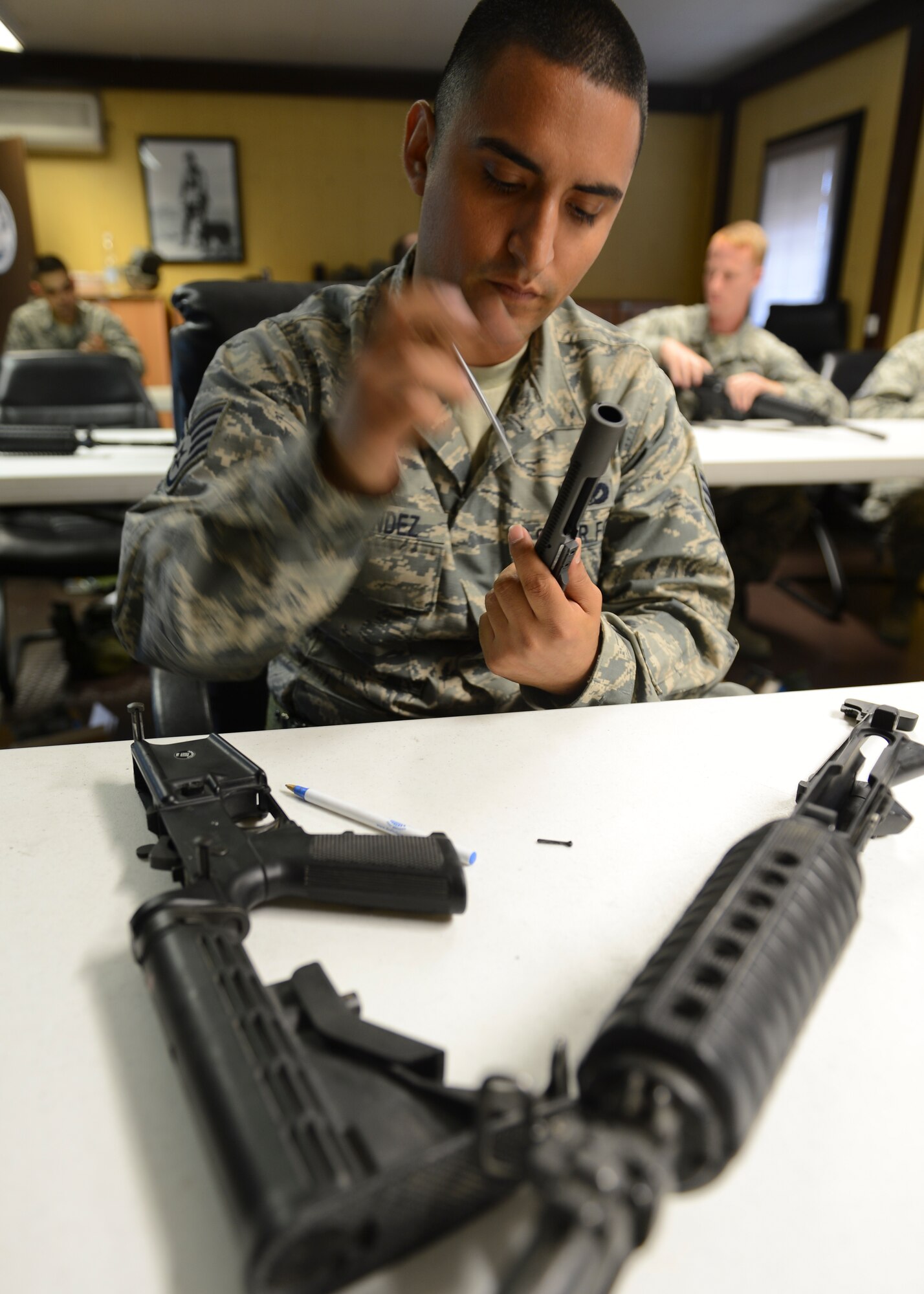 Staff Sgt. Daniel Hernandez, 786th Civil Engineer Squadron water and fuels system maintenance journeyman, disassembles an M-16 trainer weapon during Prime BEEF (Base Engineer Emergency Forces) Day, Ramstein Air Base, Germany, June 13, 2014. From Self-Aid Buddy Care to weapons handling, the 86th Civil Engineer Squadron conducts Prime BEEF training to sharpen their contingency skills.  (U.S. Air Force photo/Airman 1st Class Michael Stuart) 