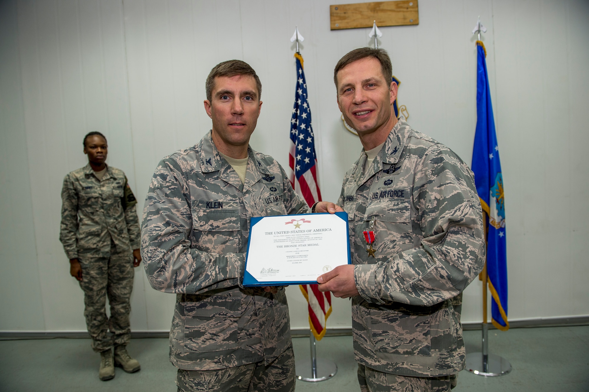 U.S. Air Force Col. John Klein, 386th Air Expeditionary Wing commander, presents Col. James Dryjanski, 387th Air Expeditionary Group commander, the Bronze Star June 22, 2014 at an undisclosed location in Southwest Asia. Dryjanski was awarded the medal just before relinquishing command of the 387th AEG during a formal change of command ceremony. (U.S. Air Force photo by Staff Sgt. Jeremy Bowcock)