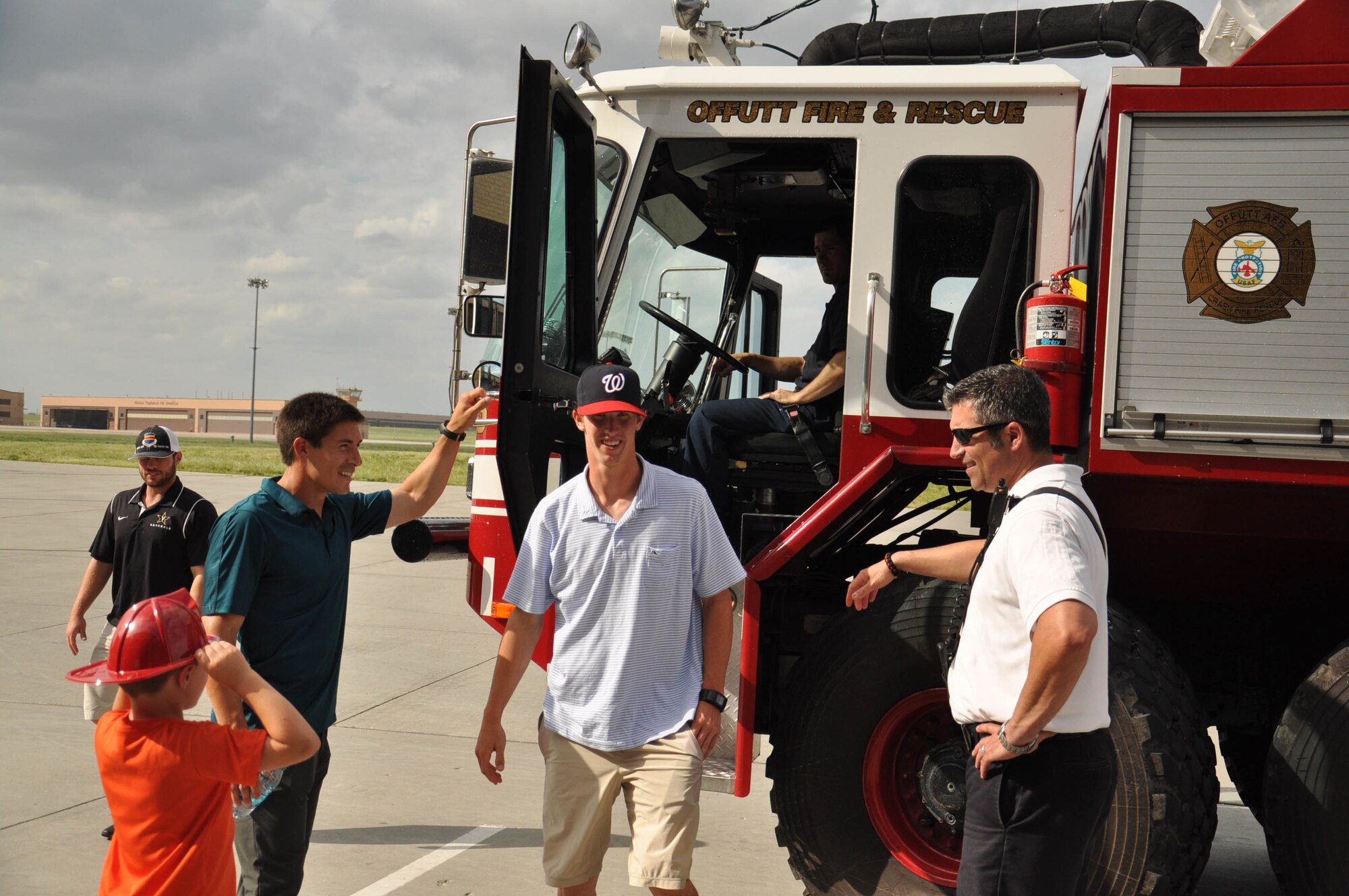 Walker Buehler, a sophomore pitcher with the Vanderbilt University baseball team, exits an Offutt Air Force Base fire truck after learning how the hoses work June 15. The team visited base as part of a sponsorship between the 55th Wing and the College World Series. (U.S. Air Force photo by 2nd Lt. Carly Costello)