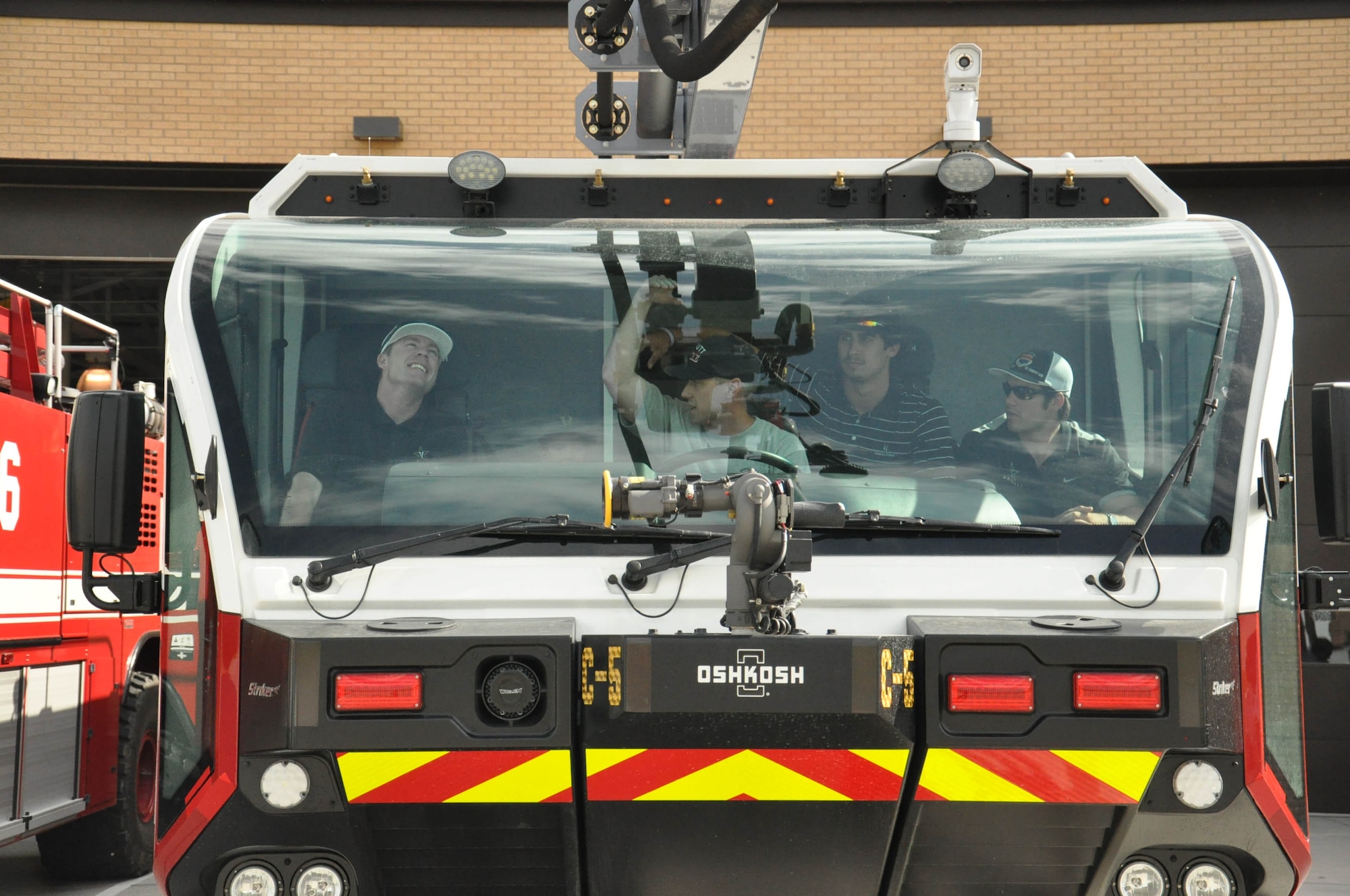 Players for the Vanderbilt University baseball team learn about the fire engines on Offutt Air Force Base, Nebraska, during a base tour June 18. The players got to ride in the trucks and learn how to use the hoses. (U.S. Air Force photo by 2nd Lt. Carly Costello)