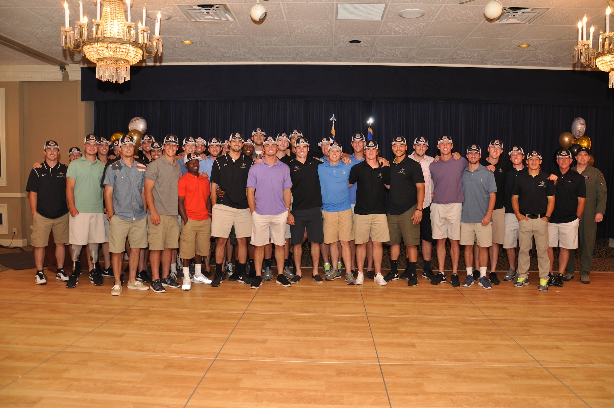 Players for the Vanderbilt University baseball team pose for a photo with U.S. Air Force Col. Gregory Guillot, 55th Wing commander, after a dinner with Team Offutt members and their families June 15 at the Patriot Club on Offutt Air Force Base, Nebraska. The team, along with coaches and family members visited the base as a part of a College World Series sponsorship the 55th Wing has with the team. (U.S. Air Force photo by 2nd Lt. Carly Costello)