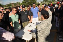 Players and coaches from the Vanderbilt University baseball team watch U.S. Air Force Staff Sgt. Ashley Gomez, 55th Security Forces Squadron, demonstrate several of their non-lethal weapons June 15 at Offutt Air Force Base. The team and the coaches learned about the mission and capabilities of the 55th Security Forces Squadron during their visit to base. (U.S. Air Force photo by 2nd Lt. Carly Costello)
