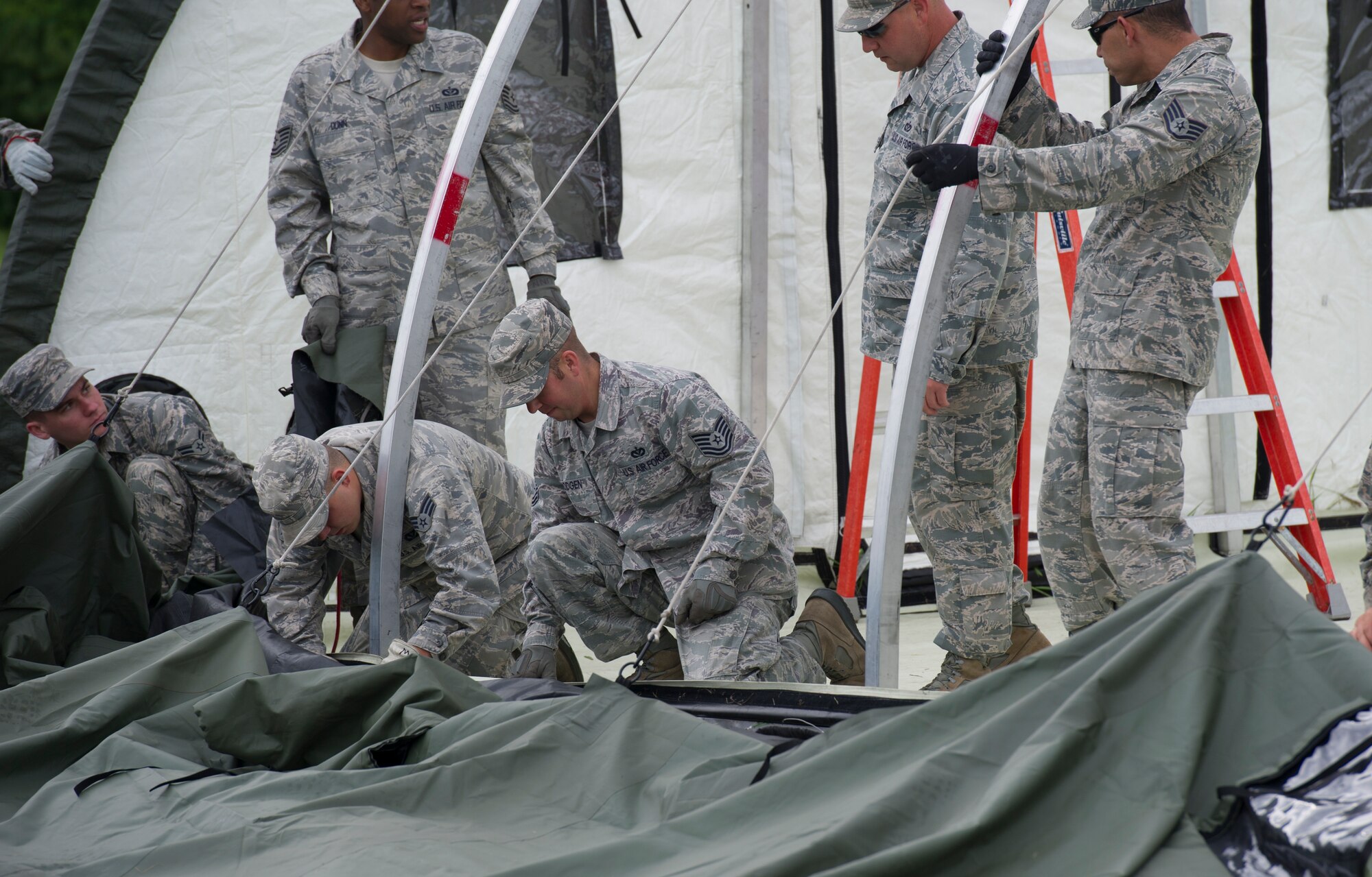 The 5th Civil Engineer Squadron conducted deployment training at Minot Air Force Base, N.D., June 18, 2014. Airmen from all ranks participated in training that taught them how to build a tent together, conduct a proper convoy and how to use some of the large mobile equipment used in a deployed environment. (U.S. Air Force photo/Senior Airman Andrew Crawford)