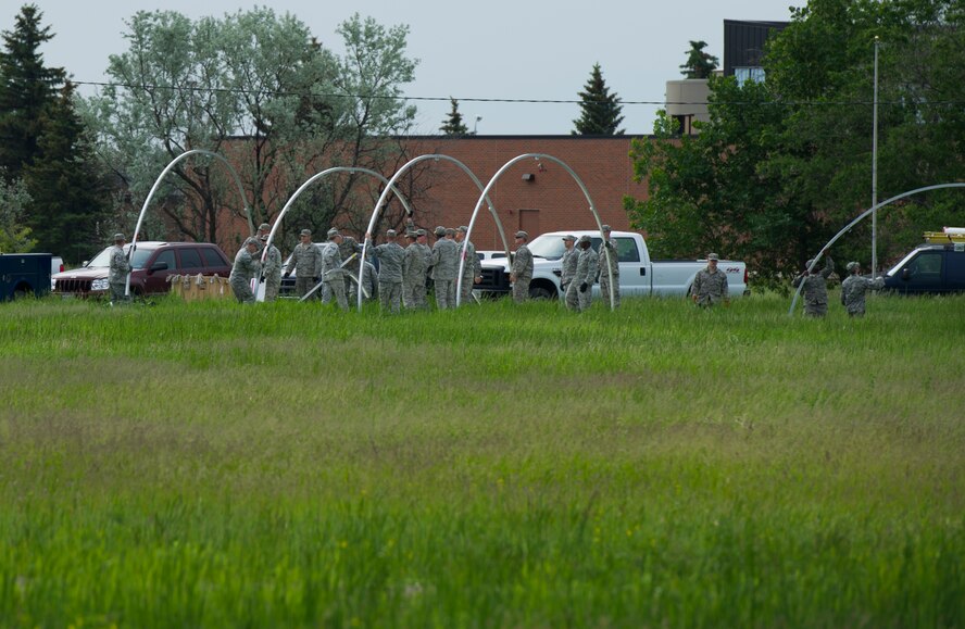 The 5th Civil Engineer Squadron conducted deployment training at Minot Air Force Base, N.D., June 18, 2014. Airmen from all ranks participated in training that taught them how to build a tent together, conduct a proper convoy and how to use some of the large mobile equipment used in a deployed environment. (U.S. Air Force photo/Senior Airman Andrew Crawford)