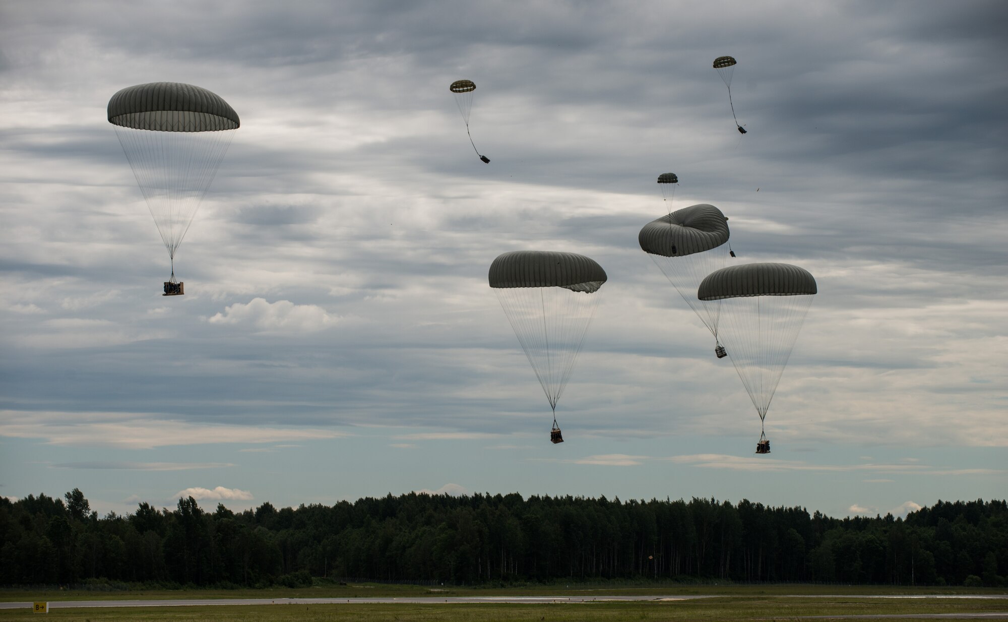 Supplies are dropped from a C-130 J-model for the 435th Contingency Response Group Airmen to build a bare base in part of the Saber Strike exercise at Lielvarde Air Base, Latvia, June 16, 2014. The 435th CRG is U.S. Air Forces in Europe and Air Force Africa's only "open the air base" force, capable of establishing contingency airfield operations and initial command and control to enable global reach and power. (U.S. Air Force photo/Senior Airman Jonathan Stefanko)