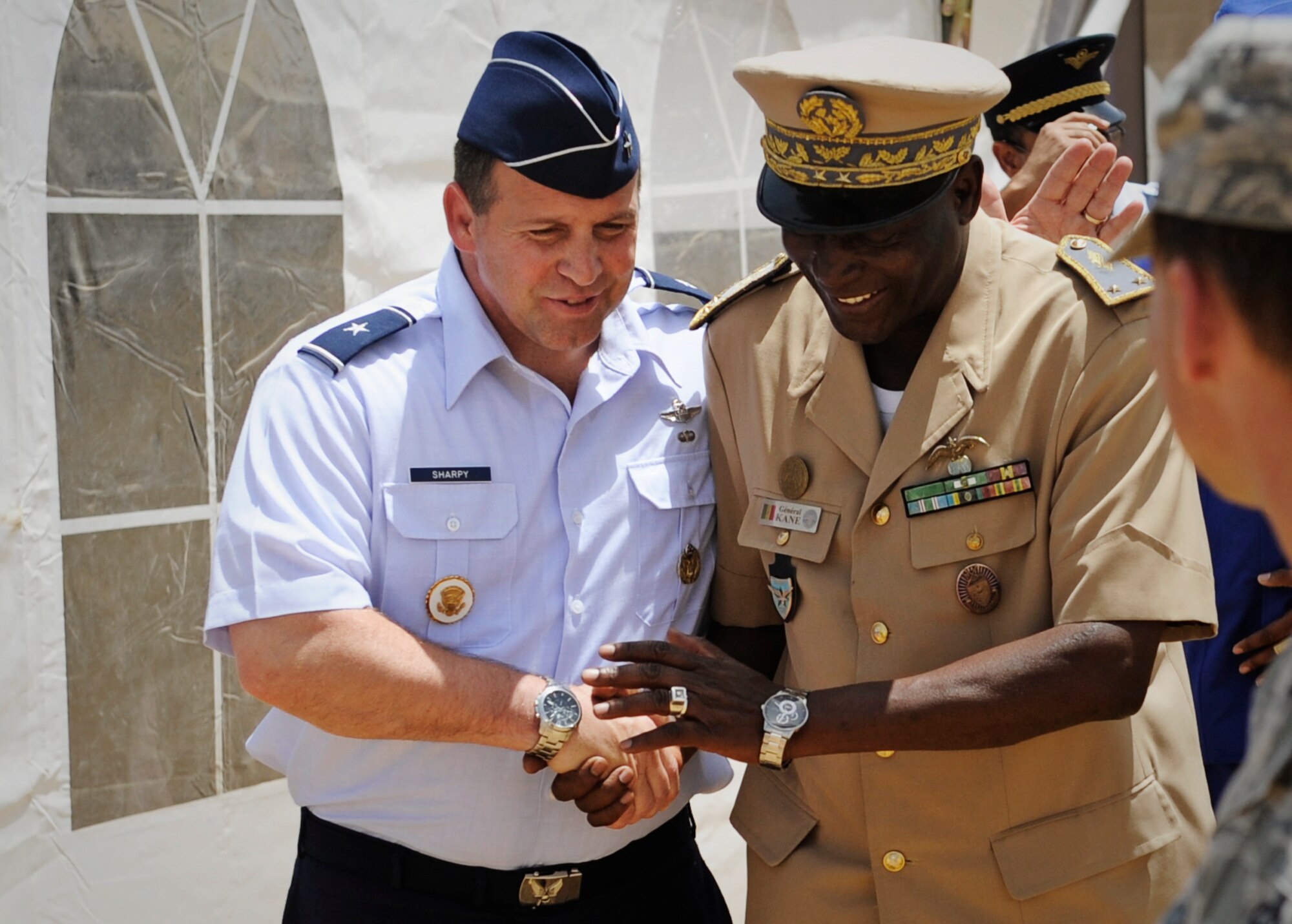 Brig. Gen. Thomas Sharpy, U.S. Air Forces in Europe and Air Forces Africa director plans, programs and analyses, shakes hands with Brig. Gen. Ousmane Kane, Senegal 's air force chief of staff, during the African Partnership Flight in Dakar, Senegal June 19, 2014. USAFE-AFAFRICA Airmen are in Senegal for APF, a program designed to improve communication and interoperabilty between regional partners in Africa. The African partners include Senegal, Togo, Burkina Faso, Benin, Ghana, Mauritania, Nigeria and Niger with the U.S. facilitating the program. (U.S. Air Force photo/ Staff Sgt. Ryan Crane)