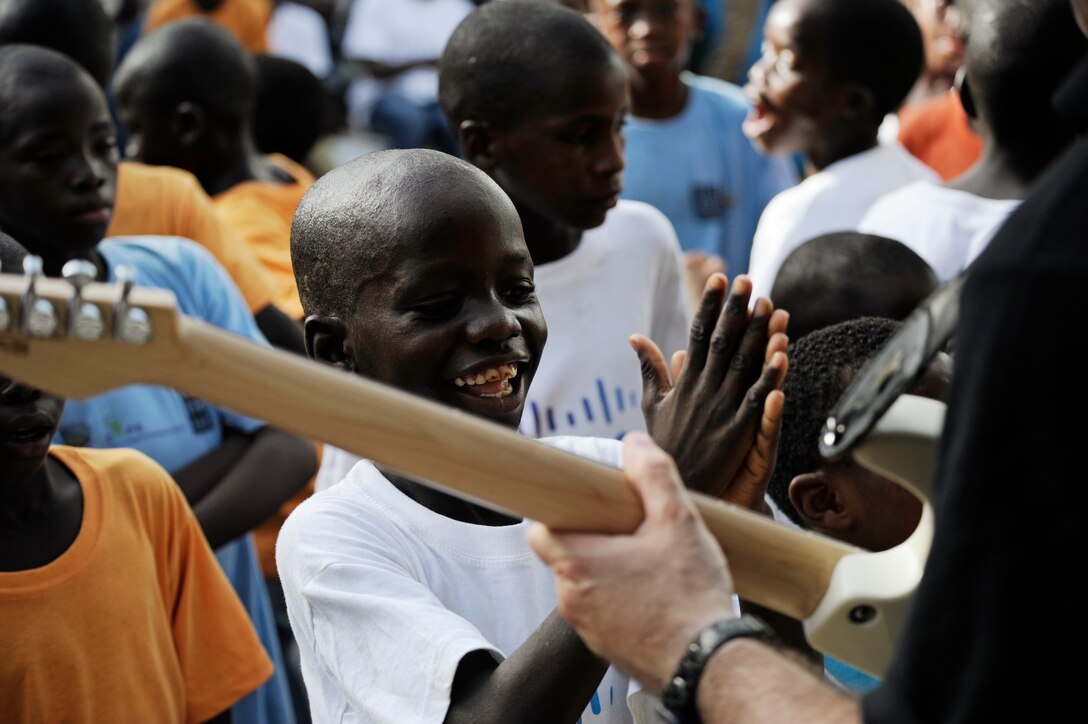 Tech. Sgt. Jason Cale, U.S. Air Forces in Europe and Air Forces Africa rock band guitarist, performs for more than 60 children during a concert at an orphanage in Dakar, Senegal June 18, 2014. USAFE-AFAFRICA Airmen are in Senegal for African Partnership Flight, a program designed to improve communication and interoperabilty between regional partners in Africa. The band will be playing multiple venues in the area to inspire children and musicians through the universal language of music. (U.S. Air Force photo/ Staff Sgt. Ryan Crane)
