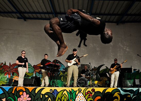 The U.S. Air Forces in Europe and Air Forces Africa rock band, "Afterburner", performs for more than 60 children while gymnasts fly through the air during a concert at an orphanage in Dakar, Senegal June 18, 2014. USAFE-AFAFRICA Airmen are in Senegal for African Partnership Flight, a program designed to improve communication and interoperabilty between regional partners in Africa. The band will be playing multiple venues in the area to inspire children and musicians through the universal language of music. (U.S. Air Force photo/ Staff Sgt. Ryan Crane)