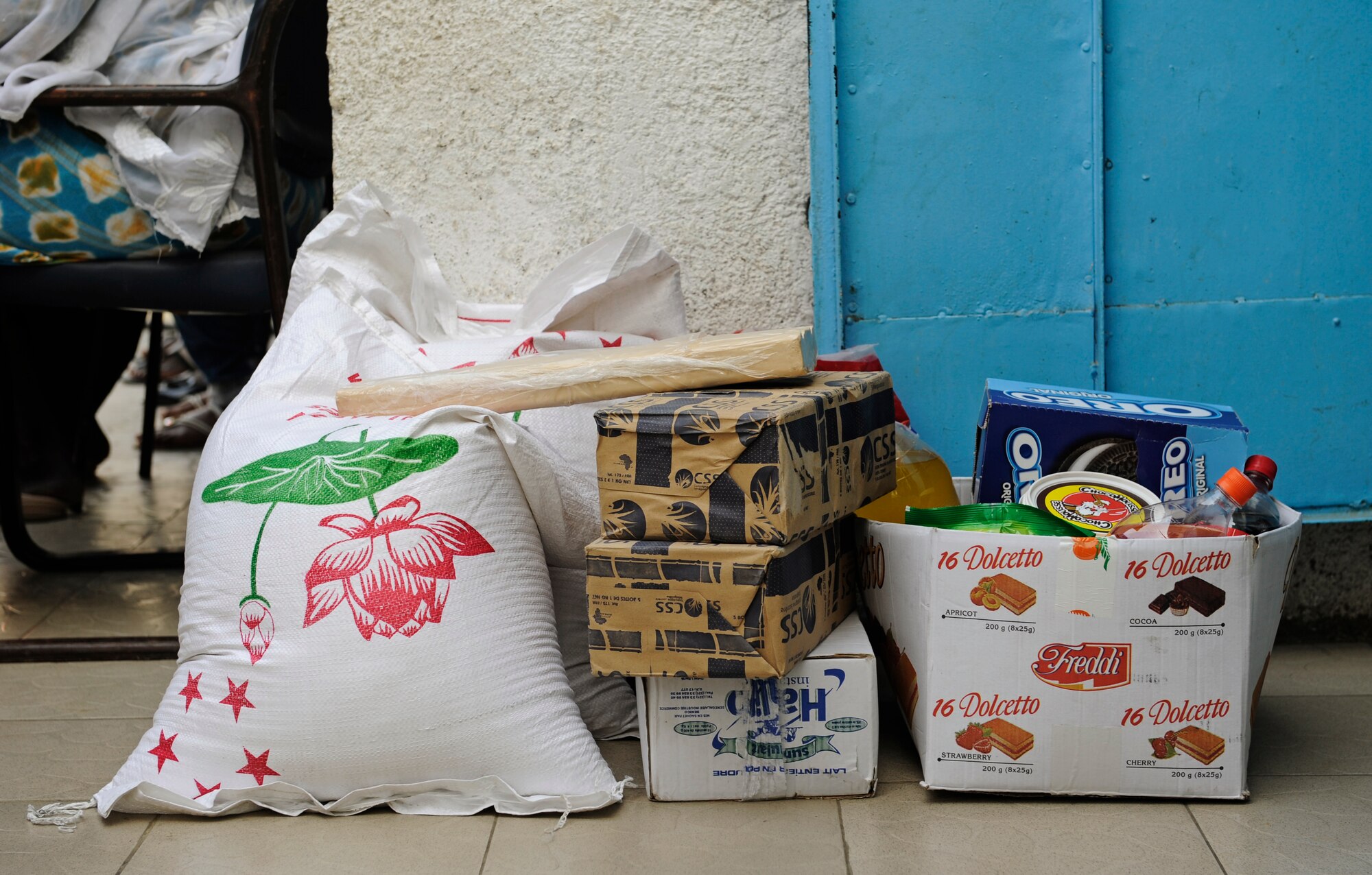 Members of the U.S. Air Forces in Europe and Air Forces Africa rock band, "Afterburner", carry donated food into an orphanage prior to a concert there in Dakar, Senegal June 18, 2014. USAFE-AFAFRICA Airmen are in Senegal for African Partnership Flight, a program designed to improve communication and interoperabilty between regional partners in Africa. The band will be playing multiple venues in the area to inspire children and musicians through the universal language of music. (U.S. Air Force photo/ Staff Sgt. Ryan Crane)