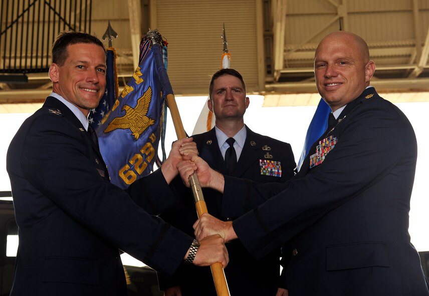 U.S. Air Force Col. Peter Milohnic, 18th Operations Group commander, passes the guidon to Maj. Daniel Biehl, 623rd Air Control Flight commander, during a change of command ceremony on Kadena Air Base, Japan, June 23, 2014. Biehl served as the 961st Airborne Air Control Squadron assistant director of operations and mission crew commander. As the assistant director of operations he assists in the safe and effective employment of two E-3 Sentry Airborne Warning and Control System aircraft assigned to the WESTPAC theater of operations. (U.S. Air Force photo by Naoto Anazawa)