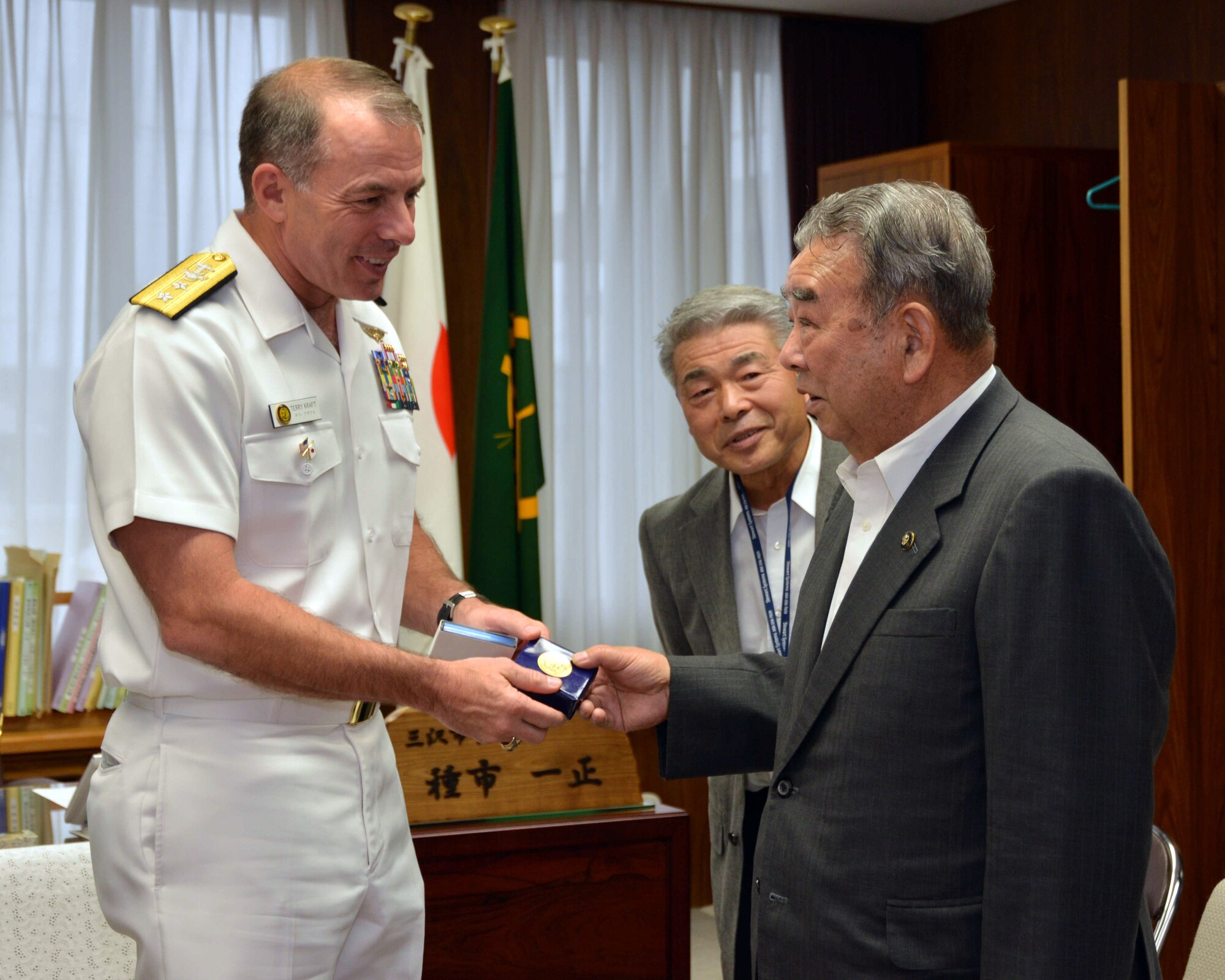 Rear Adm. Terry Kraft, U.S. Naval Forces Japan commander, left, presents a gift to Mr. Kazumasa Taneichi, Misawa City mayor, during a visit at the mayor’s office, June 19, 2014. Kraft is currently visiting NAF Misawa, and meeting with local and military Japanese national officials. He'll also take part in the NAF Misawa Change of Command Ceremony, June 20. (U.S. Navy photo by Mass Communication Specialist 3rd Class Erin Devenberg/Released) 