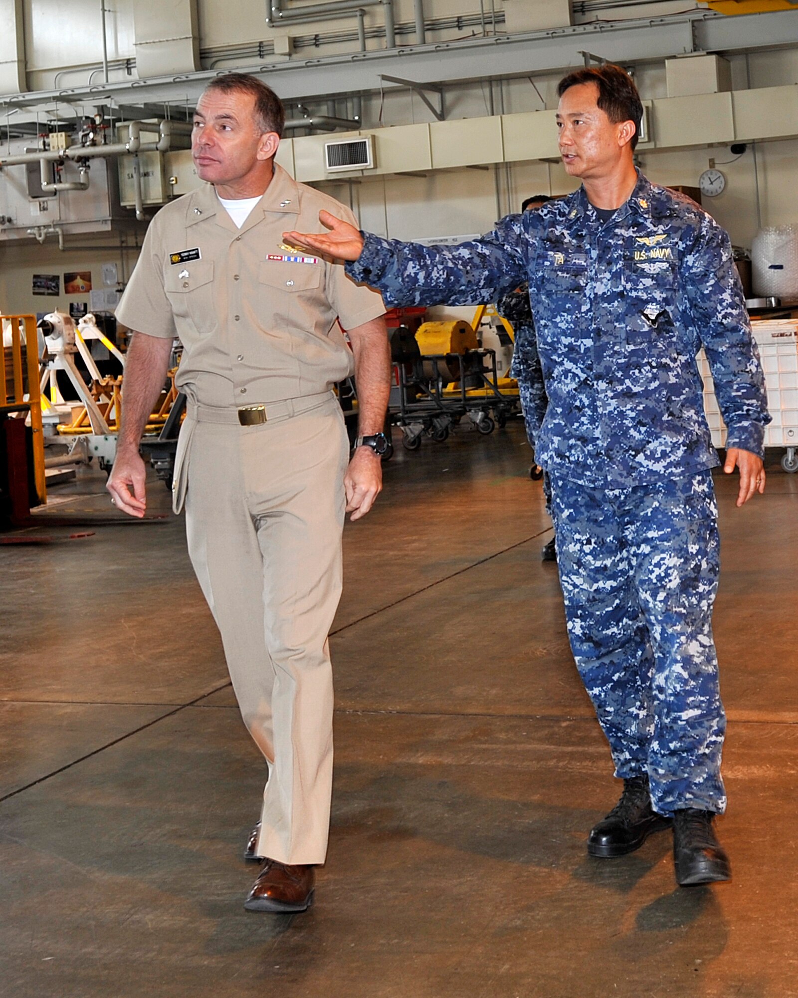 Lt. Cmdr. Michael Ta, Aircraft Intermediate Maintenance Department Misawa officer in charge, right, provides a tour of his facility for Rear Adm. Terry Kraft, U.S. Naval Forces Japan commander, June 19, 2014. Kraft is currently visiting Naval Air Facility Misawa, and is using the opportunity to meet with Sailors, and to inspect the installation’s various facilities. (U.S. Navy photo by Senior Chief Mass Communication Specialist Daniel Sanford/Released)