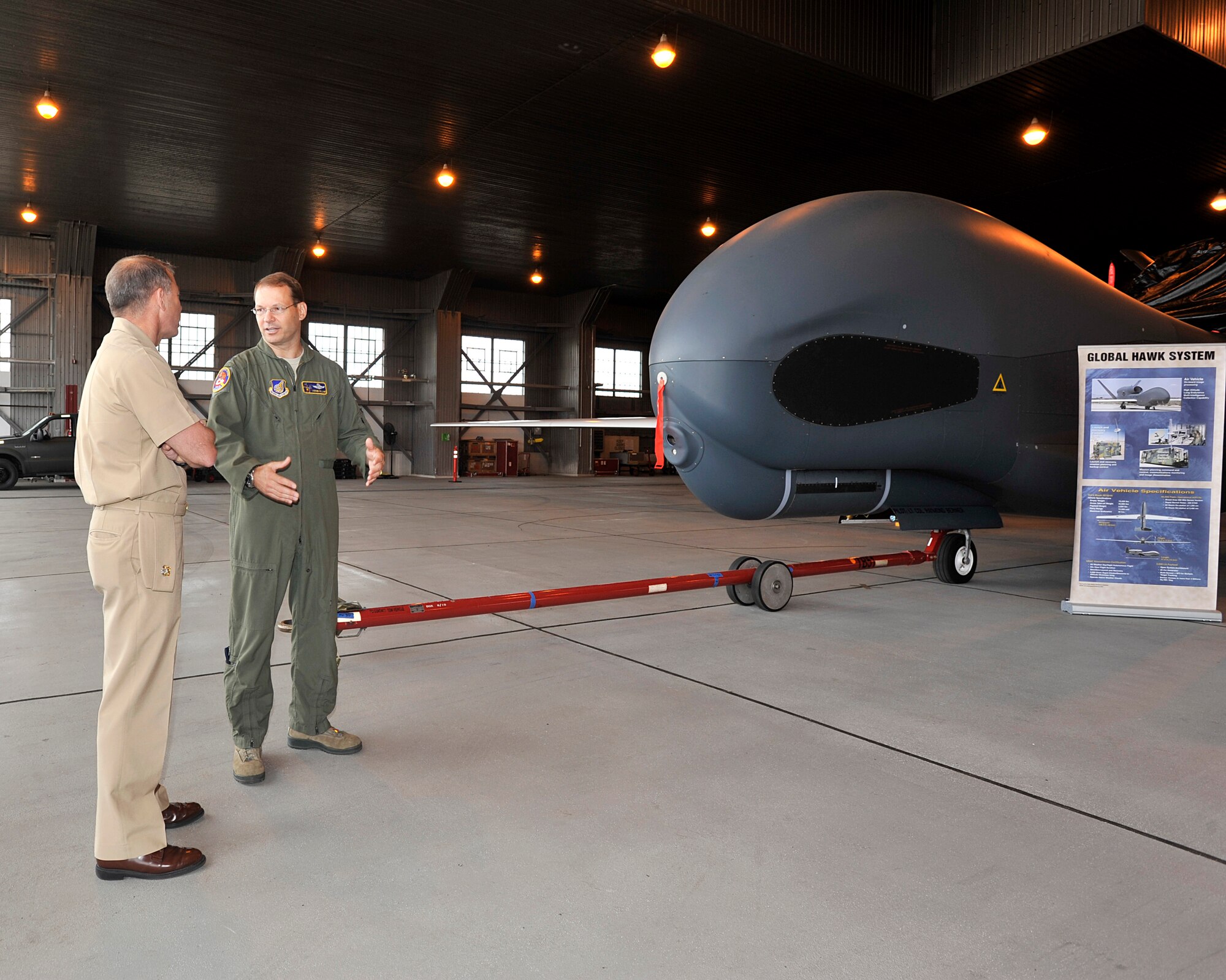 Air Force Col. Stephen Williams, right, 35th Fighter Wing commander, explains some of the capabilities of the RQ-4 Global Hawk unmanned aerial vehicle (UAV) to Rear Adm. Terry Kraft, U.S. Naval Forces Japan commander, during a tour on board Naval Air Facility Misawa, June 19, 2014. Kraft is currently visiting NAF Misawa, and is using the opportunity to meet with Sailors, and to inspect the installation’s various facilities. (U.S. Navy photo by Senior Chief Mass Communication Specialist Daniel Sanford/Released)