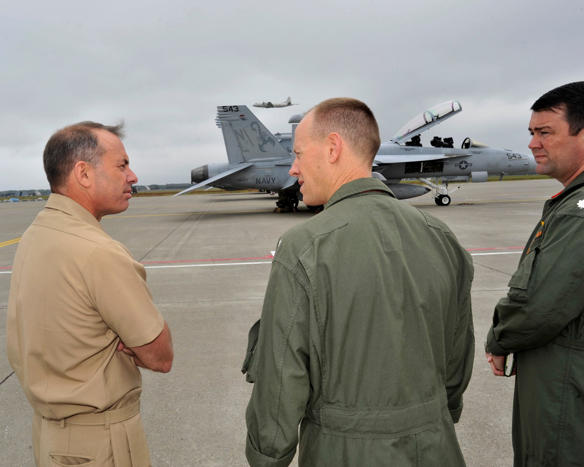 Rear Adm. Terry Kraft, U.S. Naval Forces Japan commander, left, talks with Cmdr. William McCombs, center, Electronic Attack Squadron (VAQ) 132 commanding officer, and Cmdr. Robert Holmes, VAQ-132 executive officer, while touring the Naval Air Facility Misawa (NAF) flight ramp, June 19, 2014. Kraft is currently visiting NAF Misawa, and is using the opportunity to meet with Sailors, and to inspect the installation’s various facilities. VAQ-132 is currently deployed to NAF Misawa in support of U.S. 7th Fleet operations. (U.S. Navy photo by Senior Chief Mass Communication Specialist Daniel Sanford/Released)